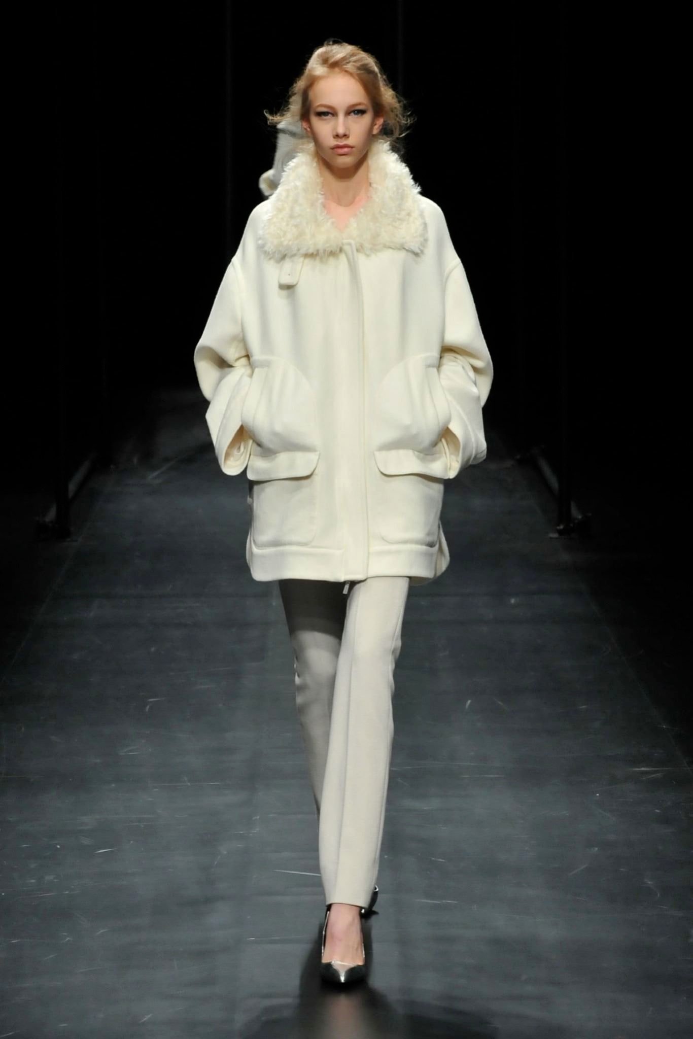 An oversized white wool coat with a collared neckline and buttoned front.