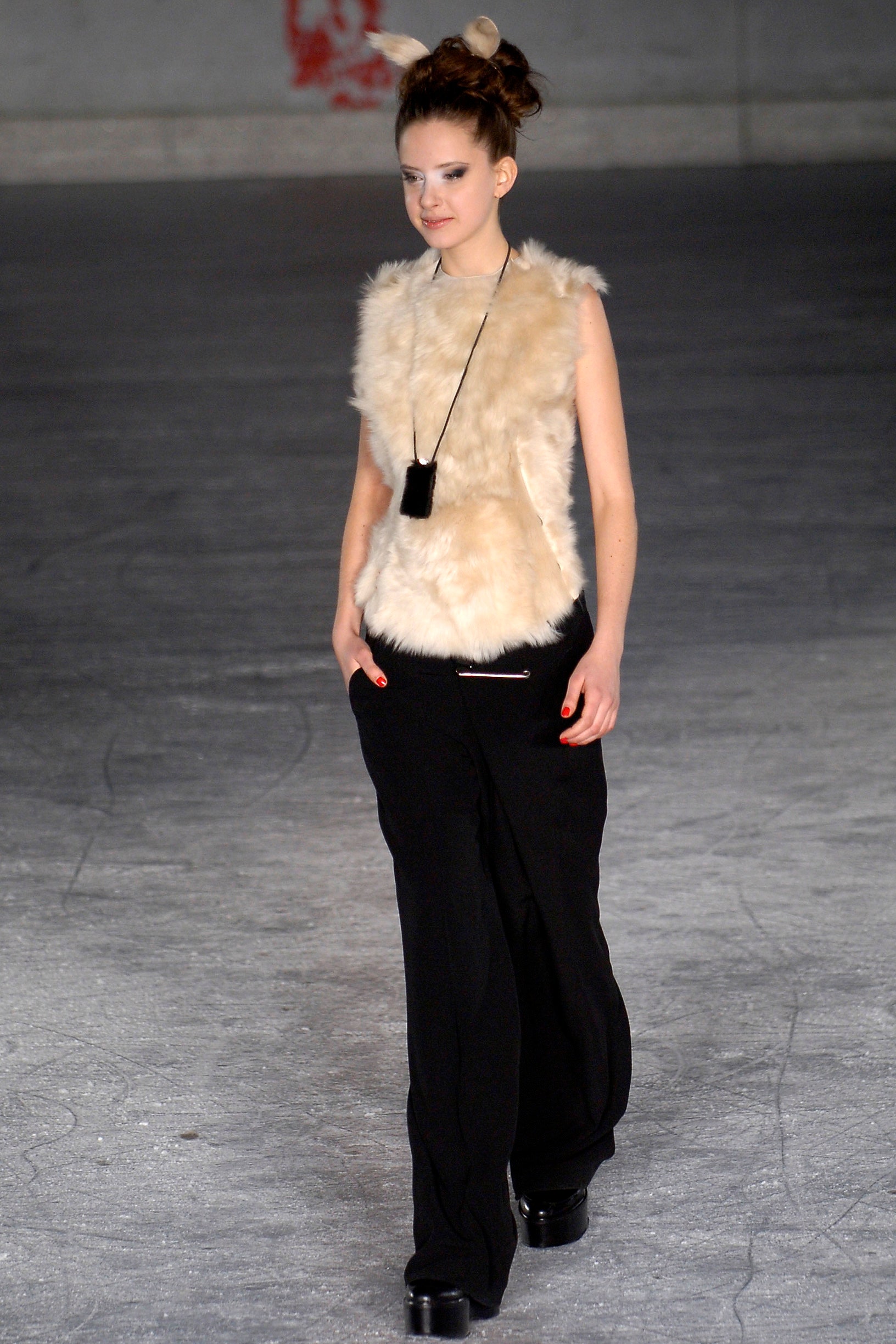 beige fur sleeveless top and black pants