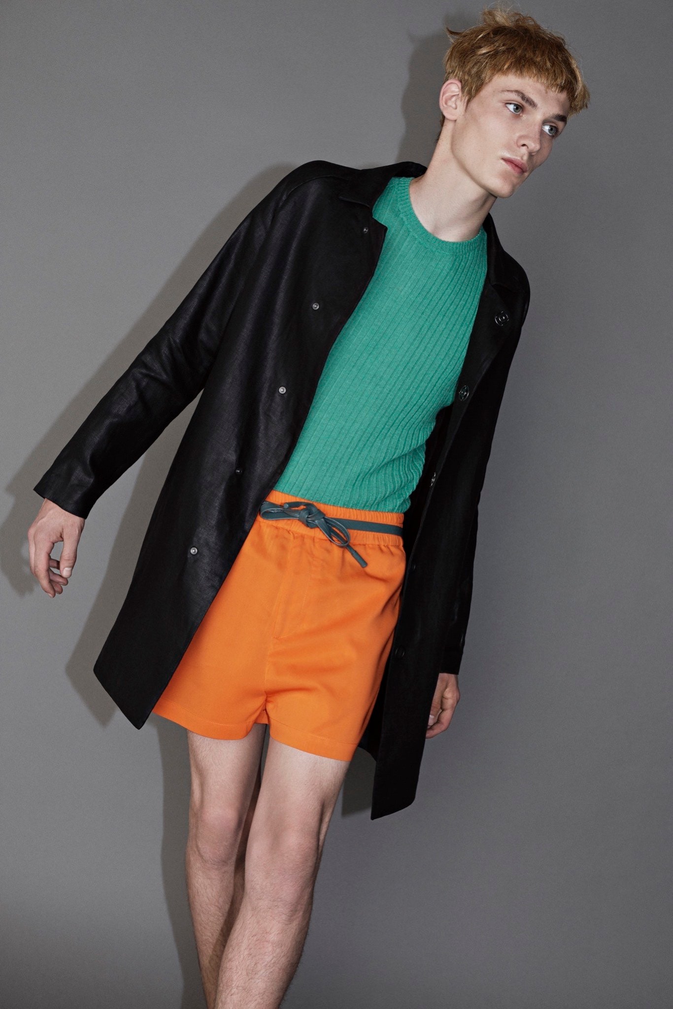 black leather coat green sweater orange shorts