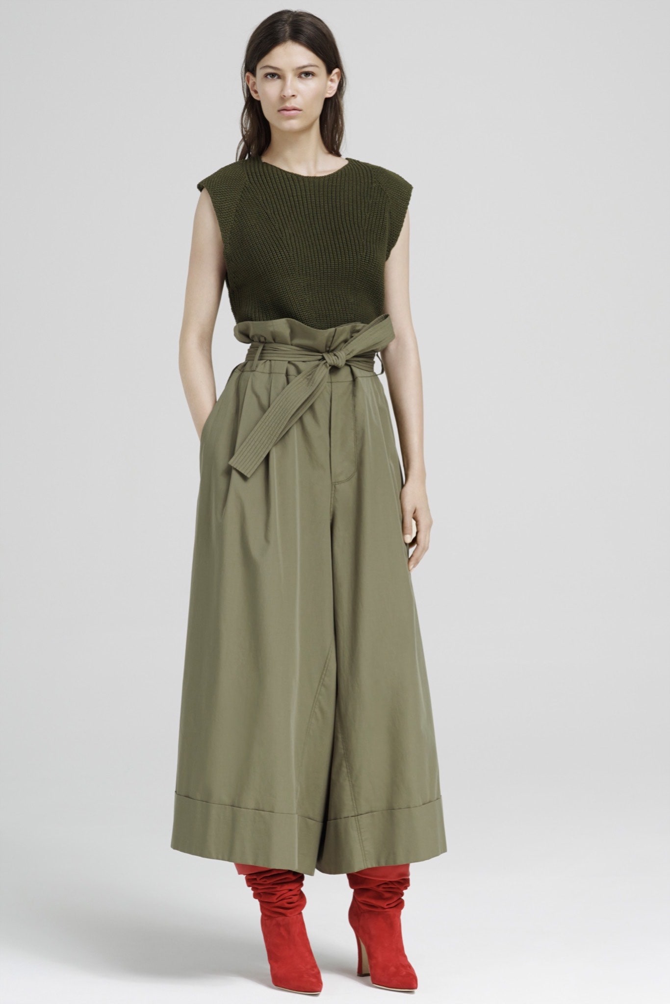 green ribbed top beige pleated pants red boots