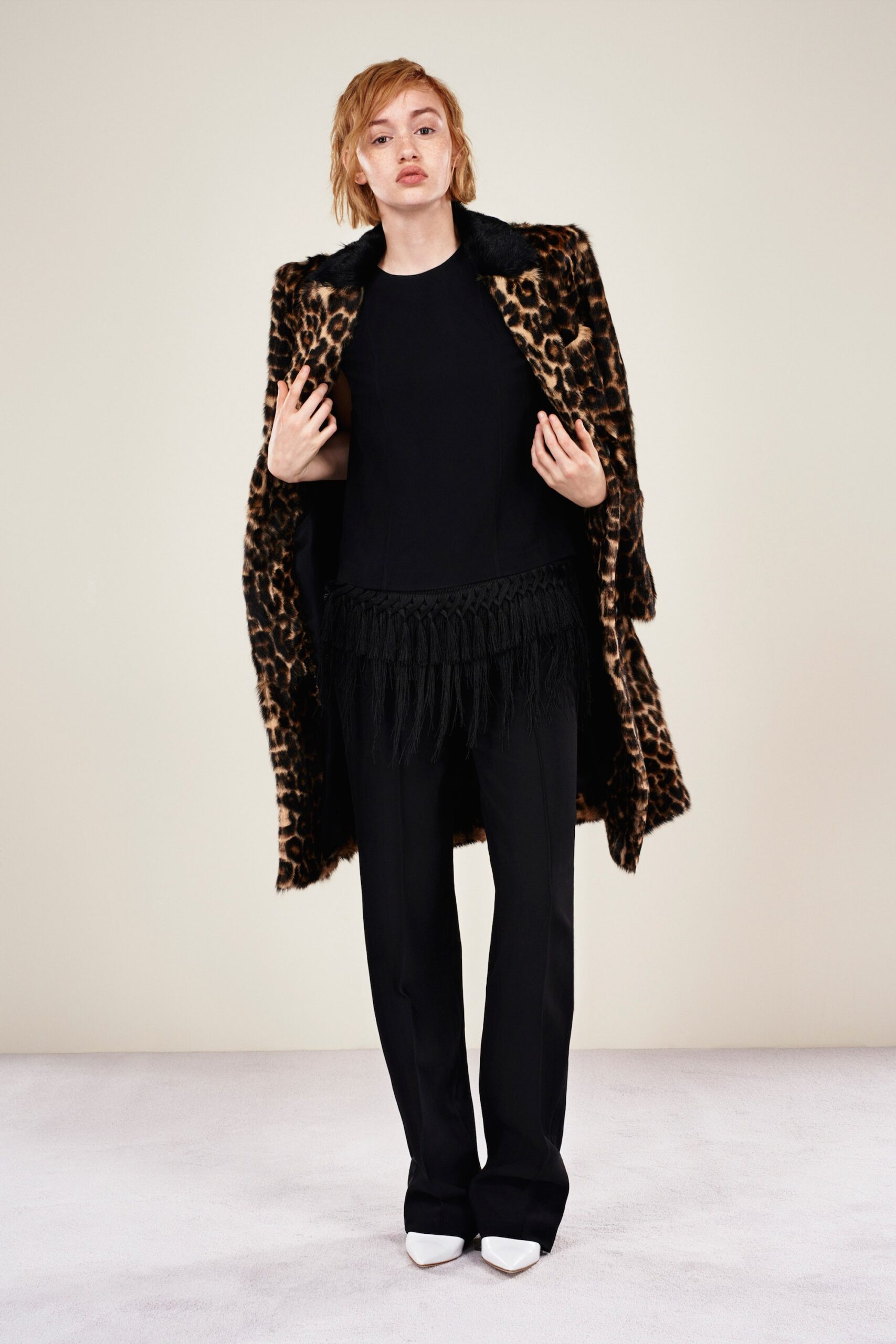 brown faux-fur coat with black top and tailored pants