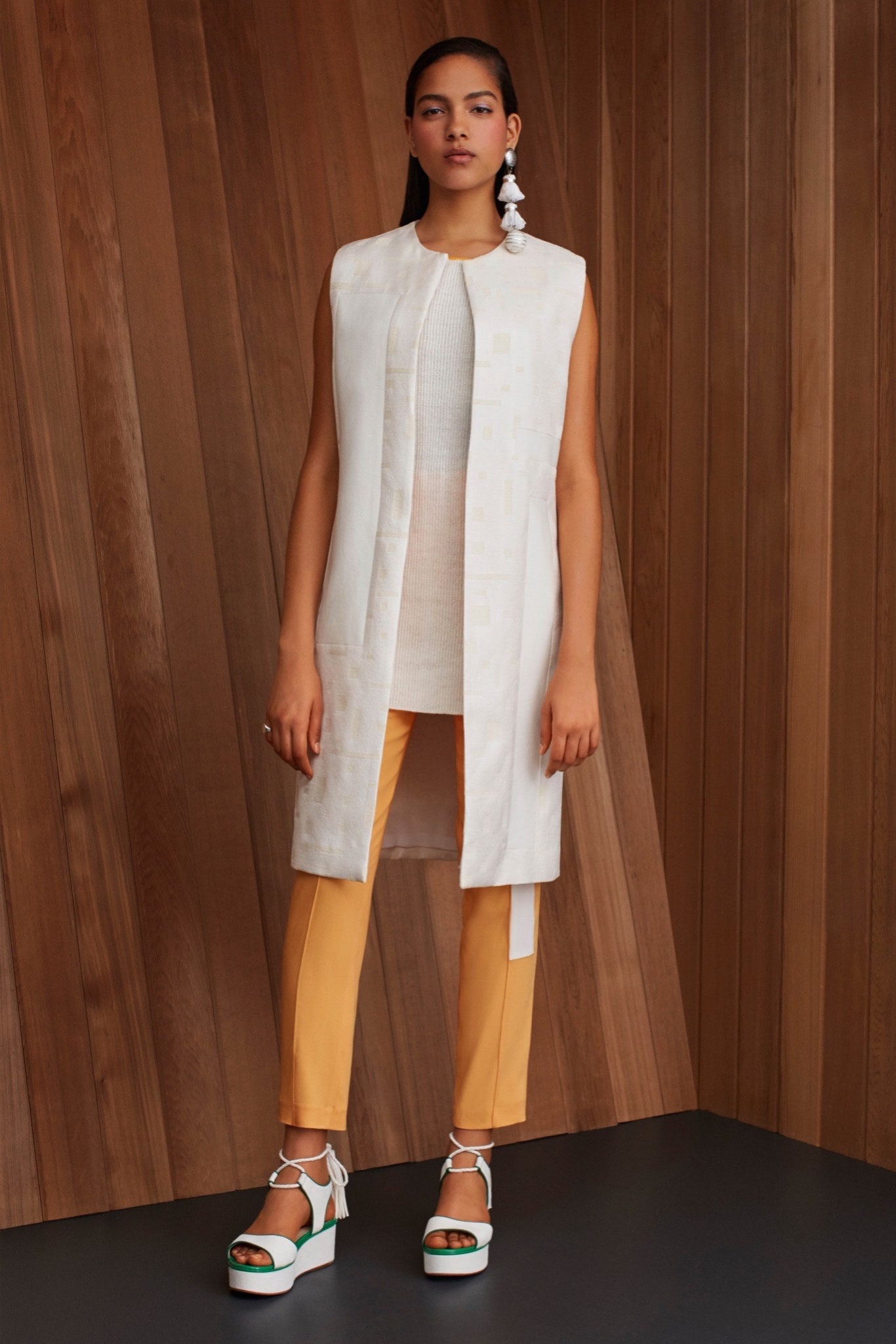 white silk sleeveless top with orange pants