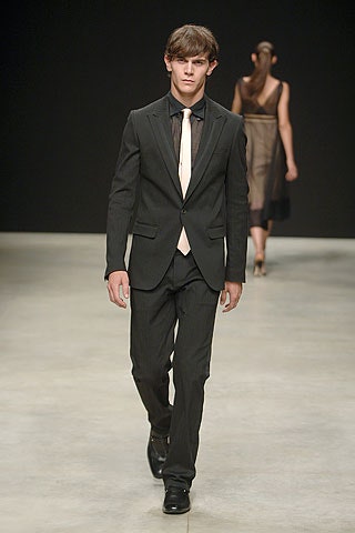 black tailored suit with beige tie