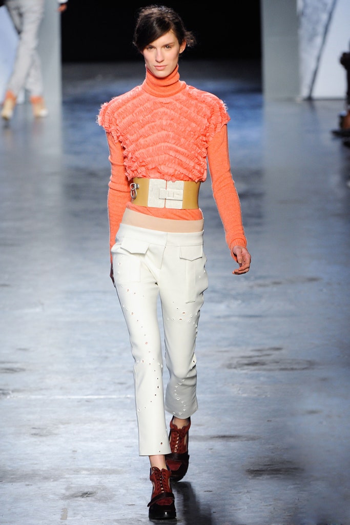 orange ruffled top with white tailored pants