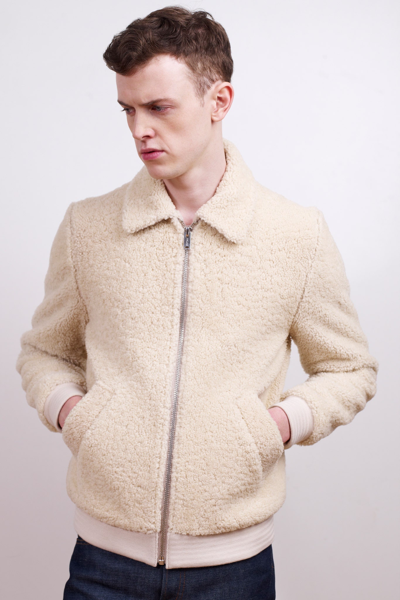 beige faux-fur jacket with blue jeans