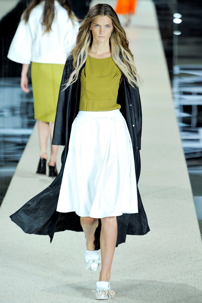 black coat green top white skirt