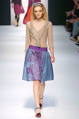 beige silk ruffled blouse and blue pleated skirt