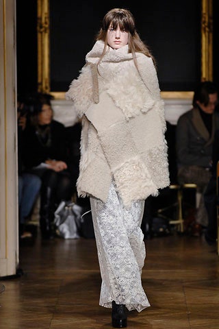 beige faux-fur cape and white flared pants