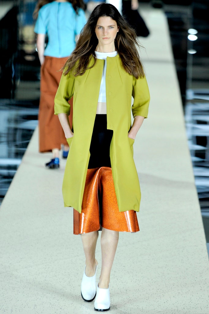 green coat white top orange skirt