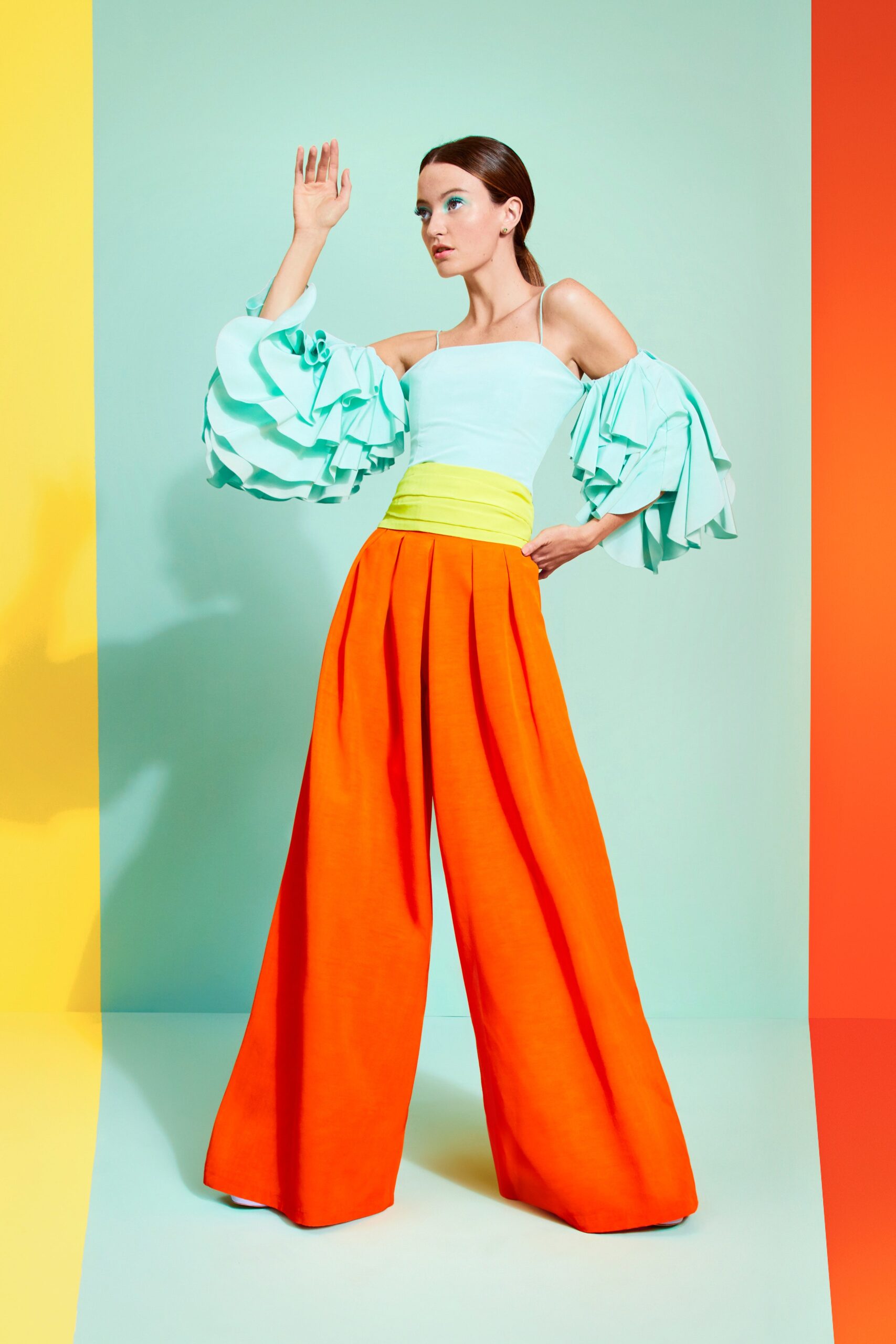 light blue pleated top and orange pants