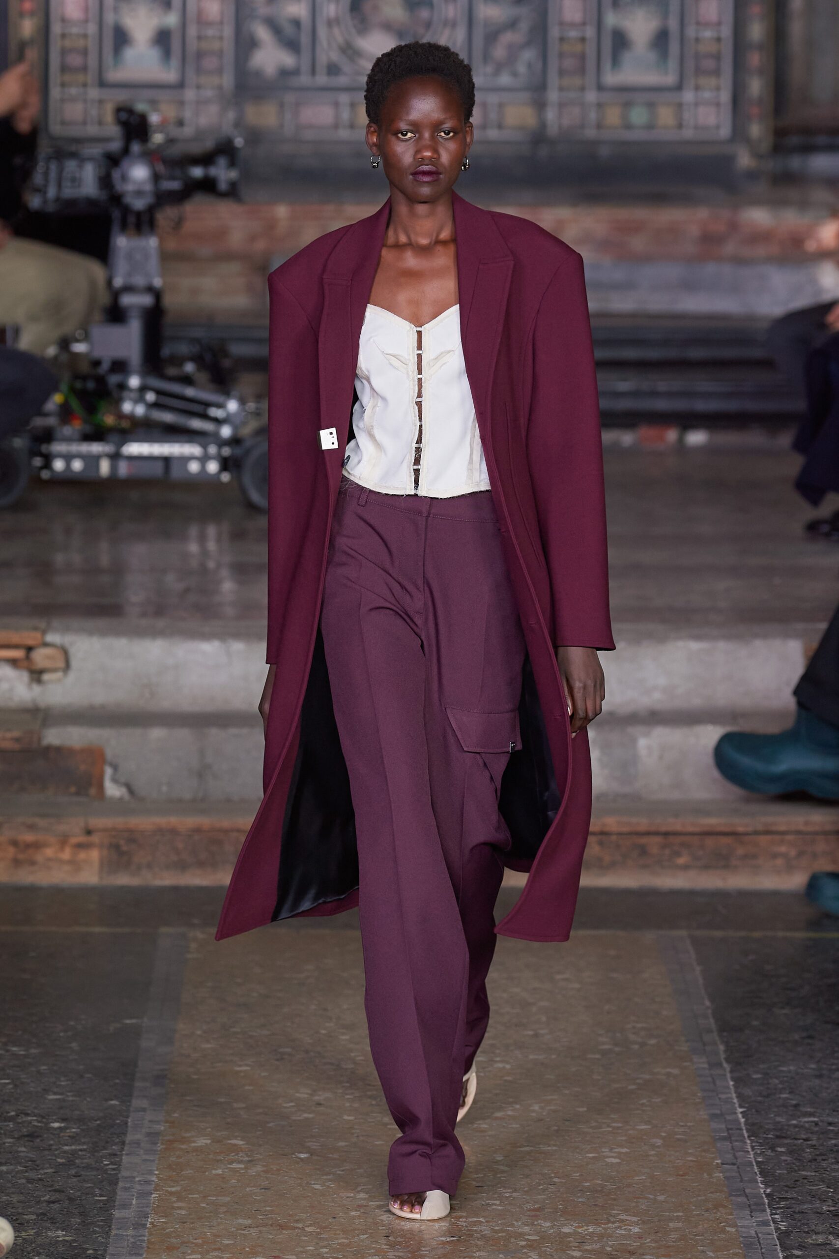 maroon coat and tailored pants
