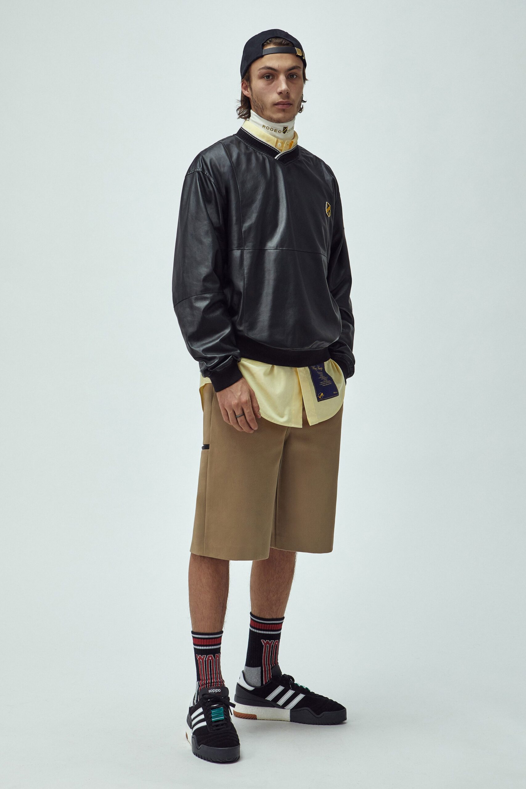 black leather relaxed top and beige shorts