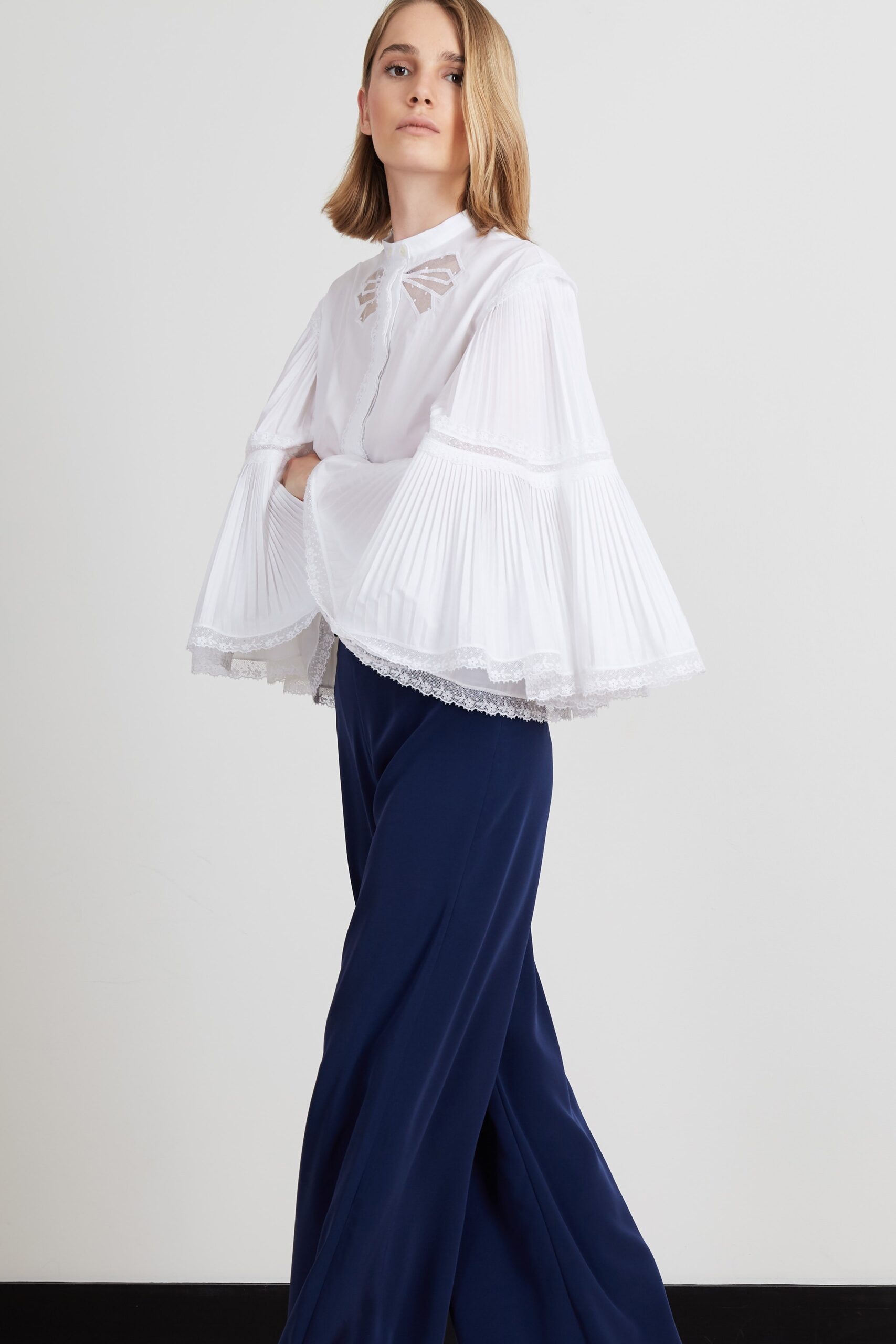 white pleated blouse with blue pants