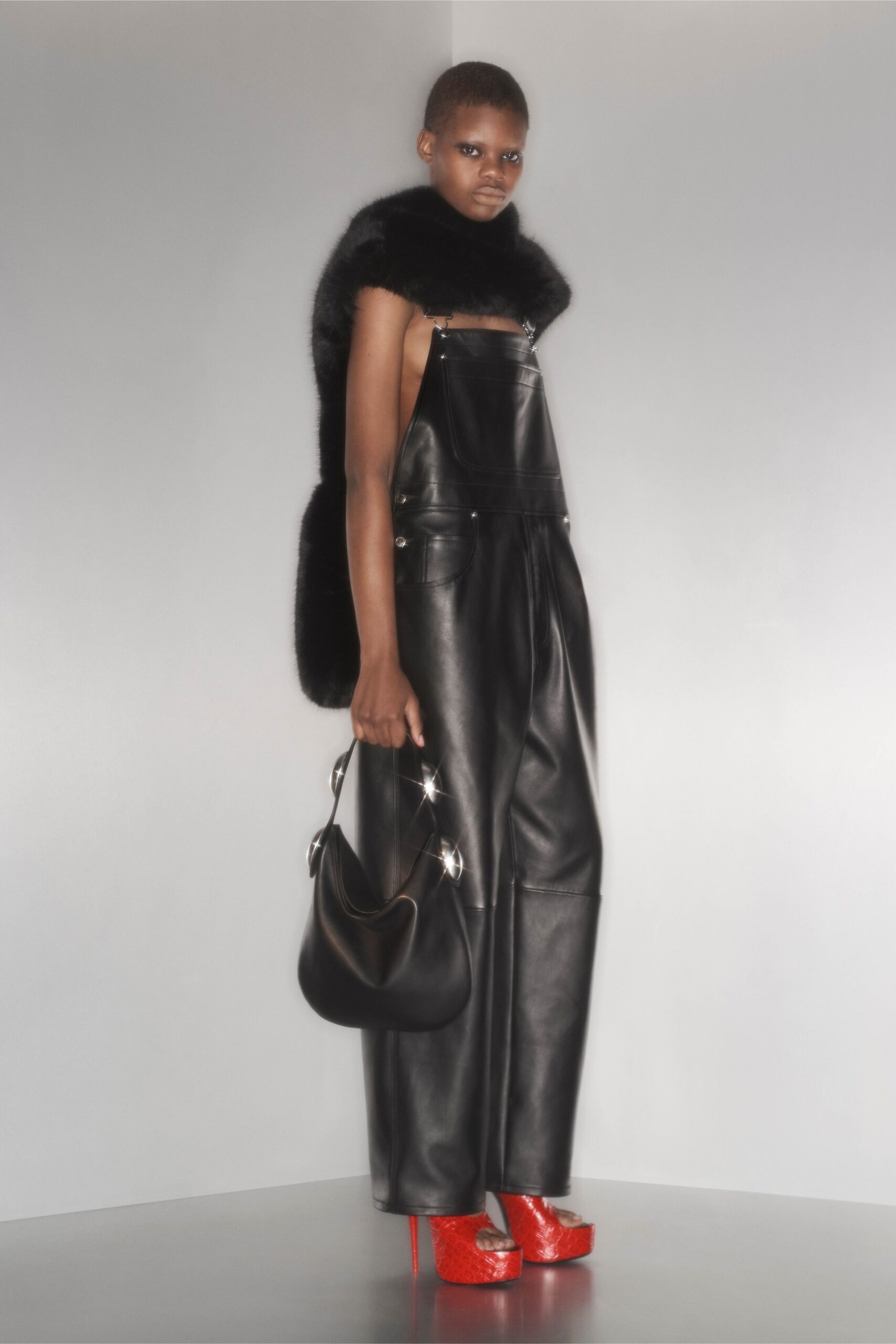 black leather jumpsuit with red shoes