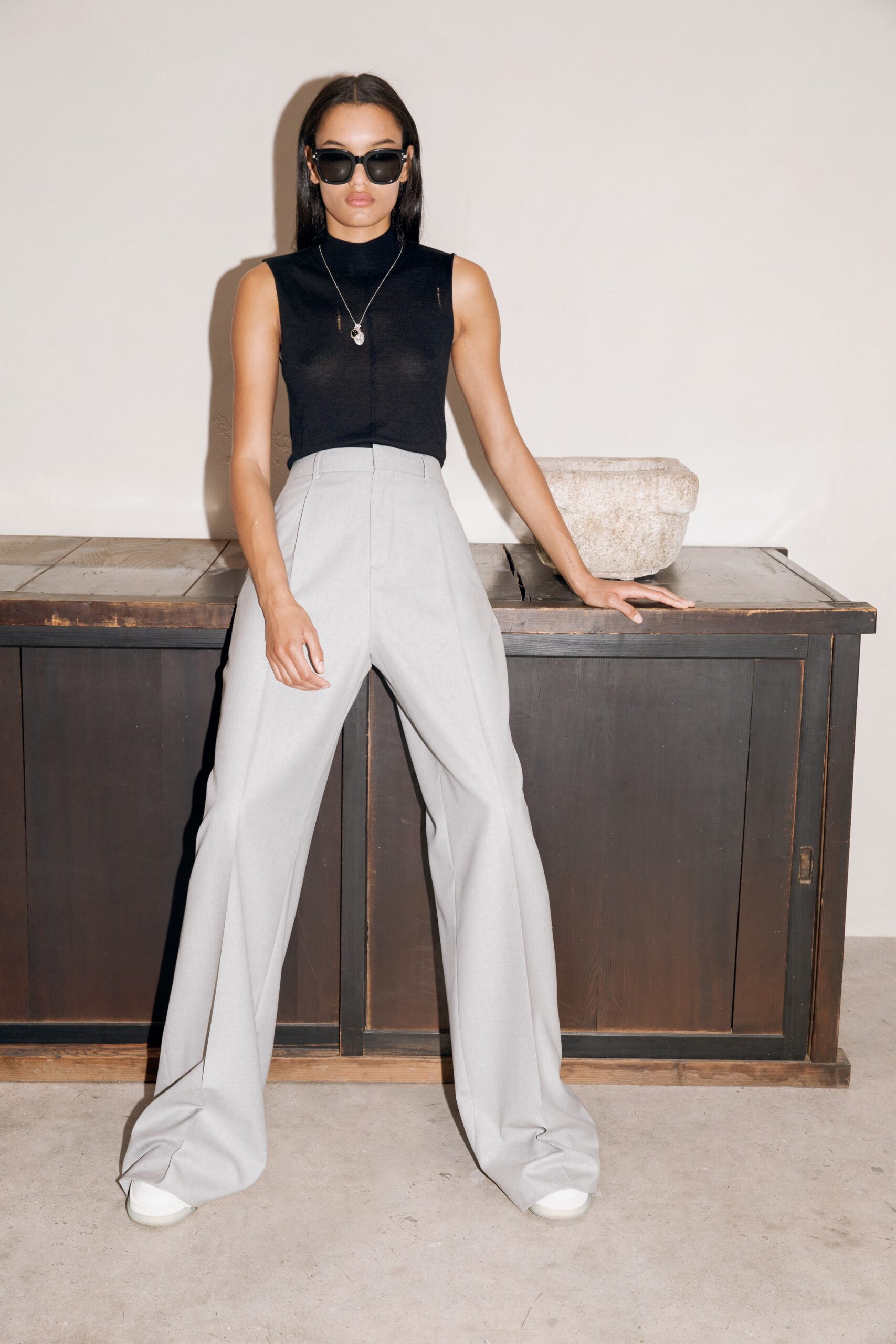 black fitted sleeveless top with gray tailored pants