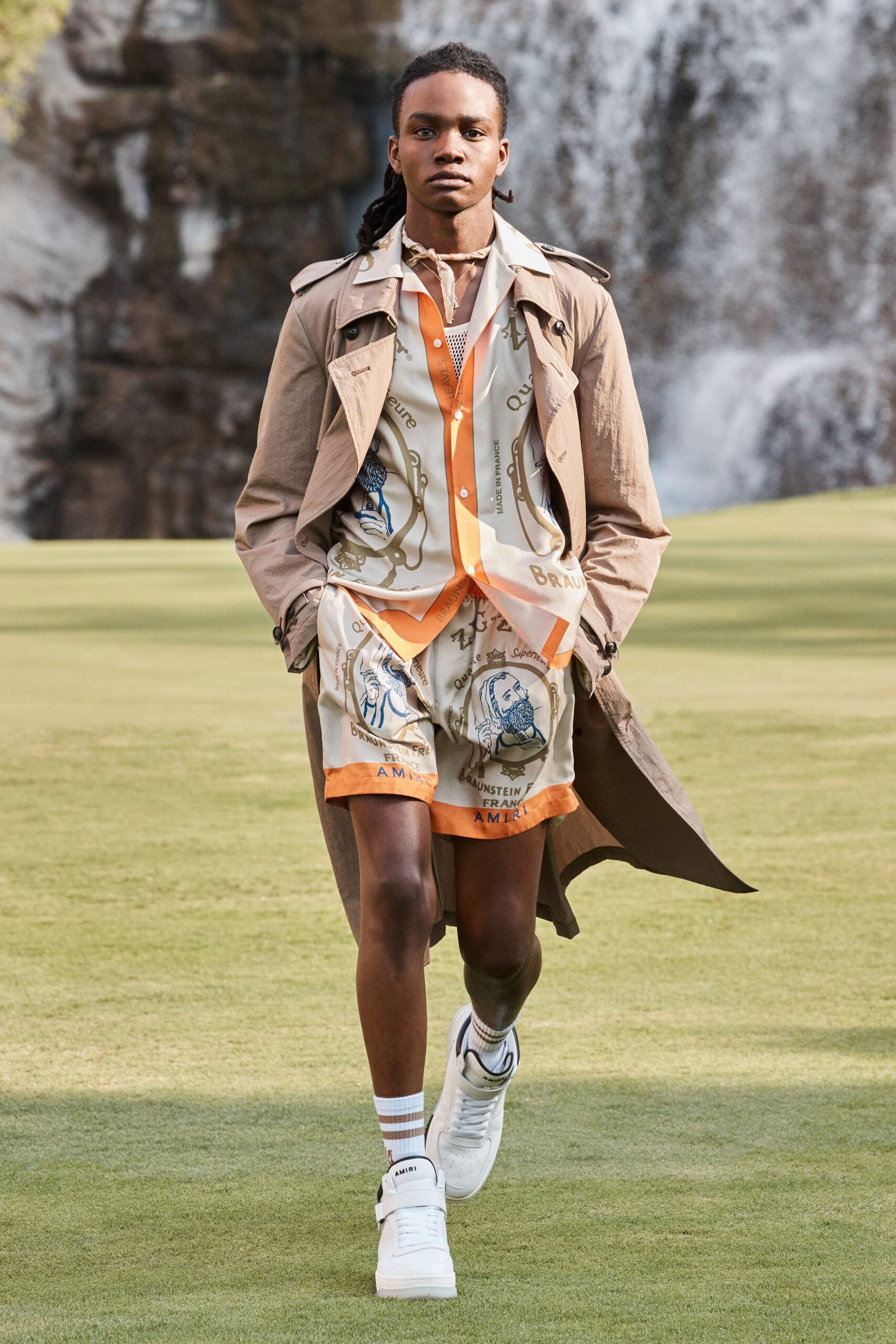beige trench coat with printed shirt and shorts
