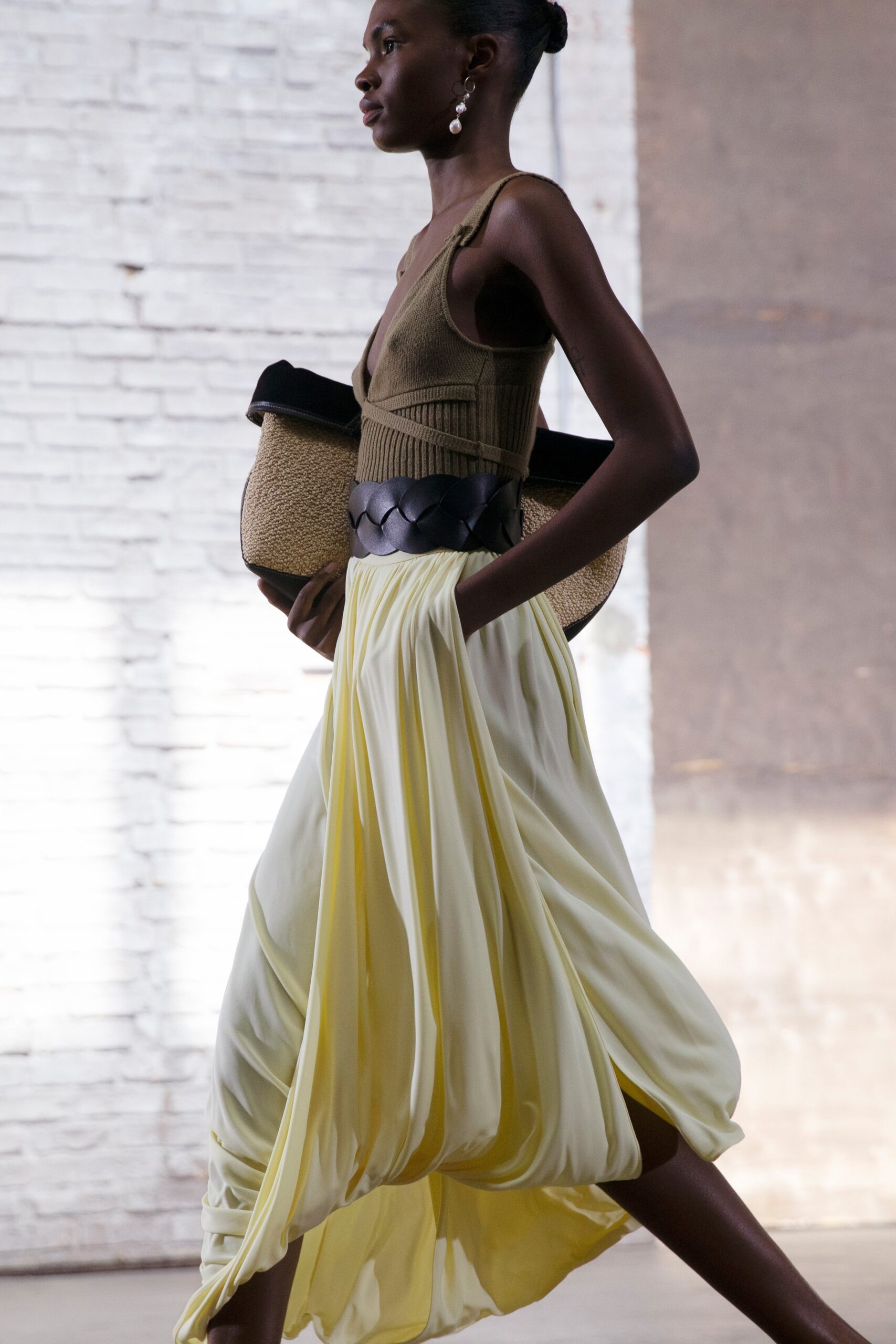 brown ribbed sleeveless top and yellow pleated skirt