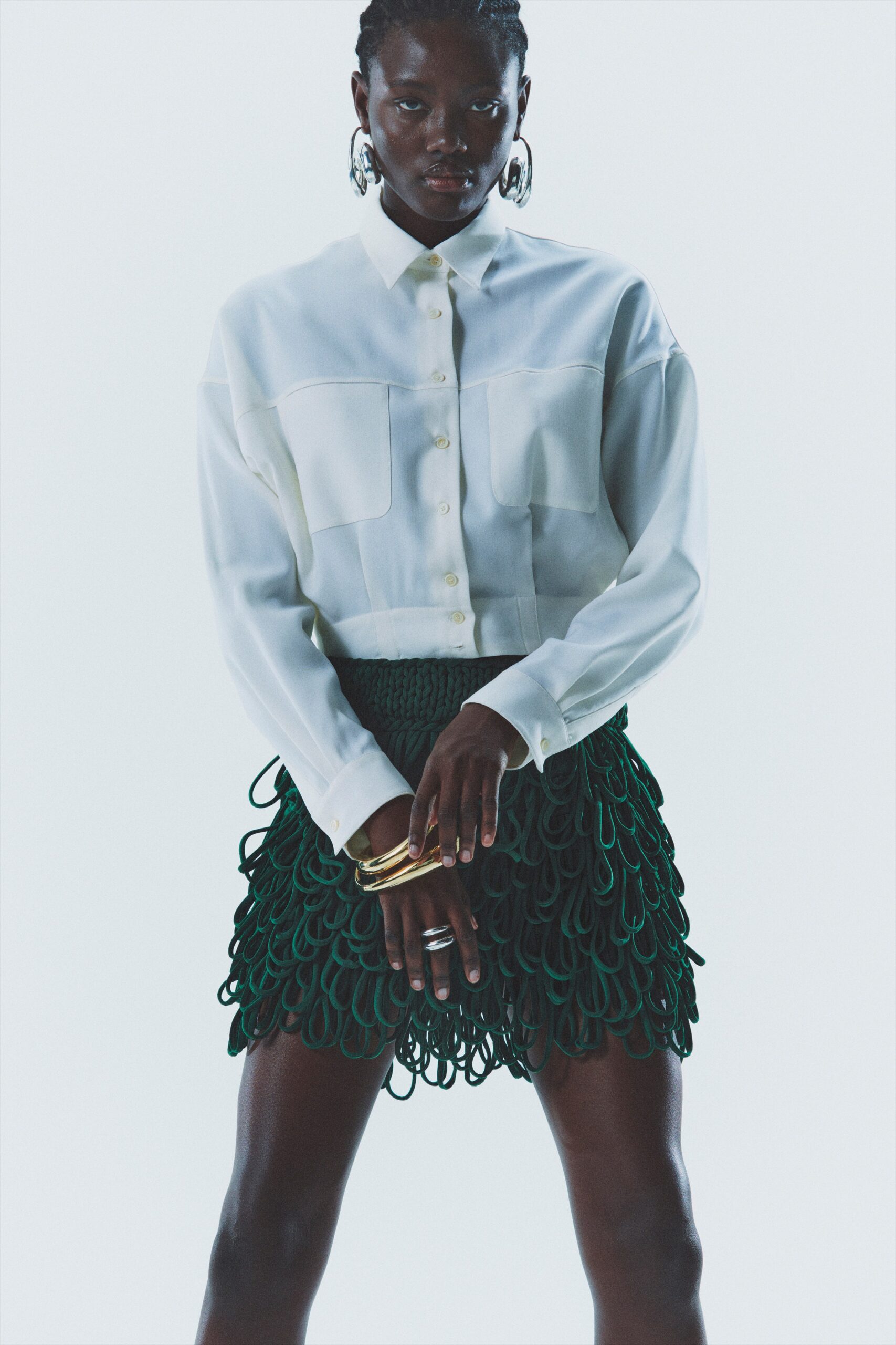 white fitted shirt and green fringed skirt