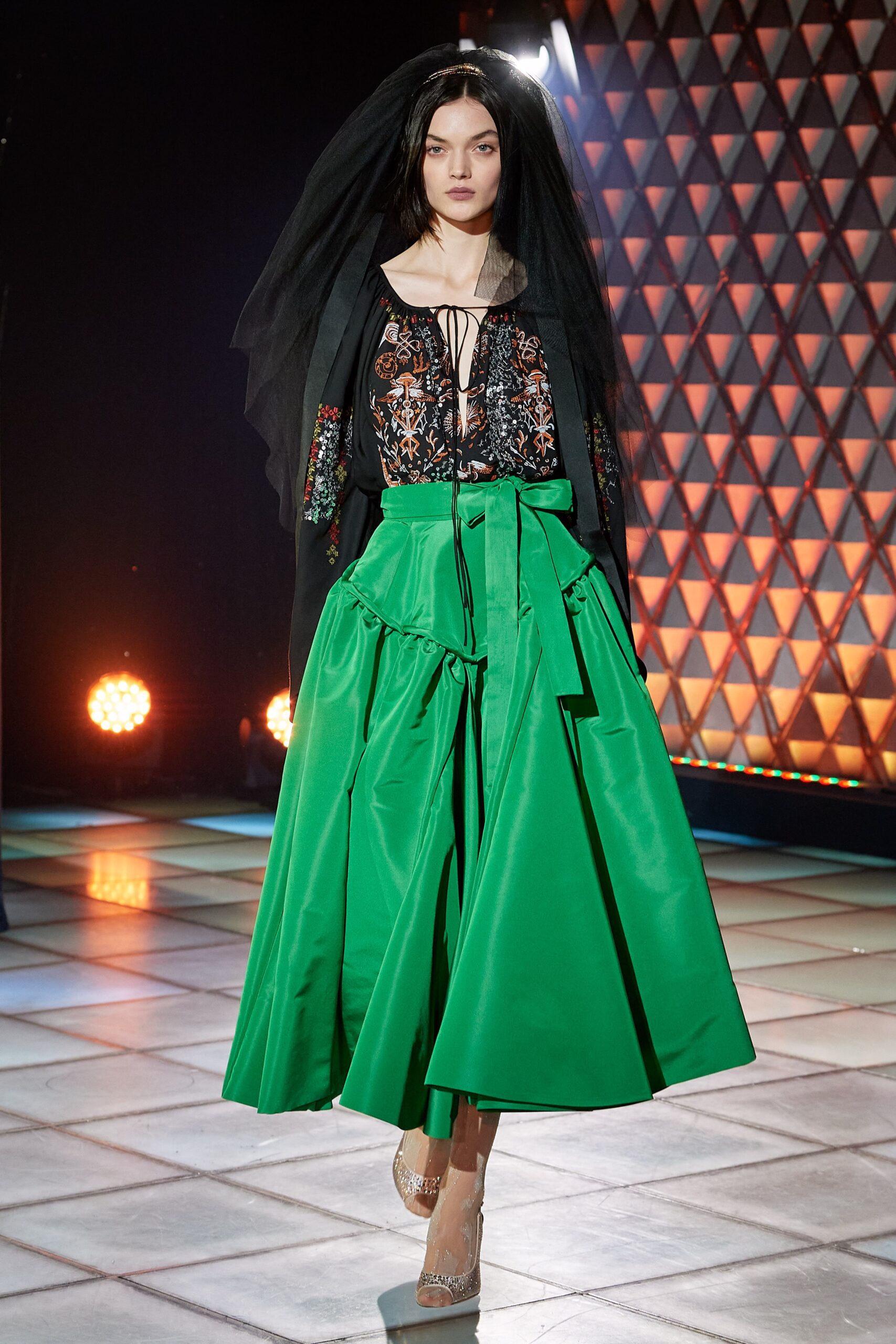 black silk embroidered blouse and green pleated skirt