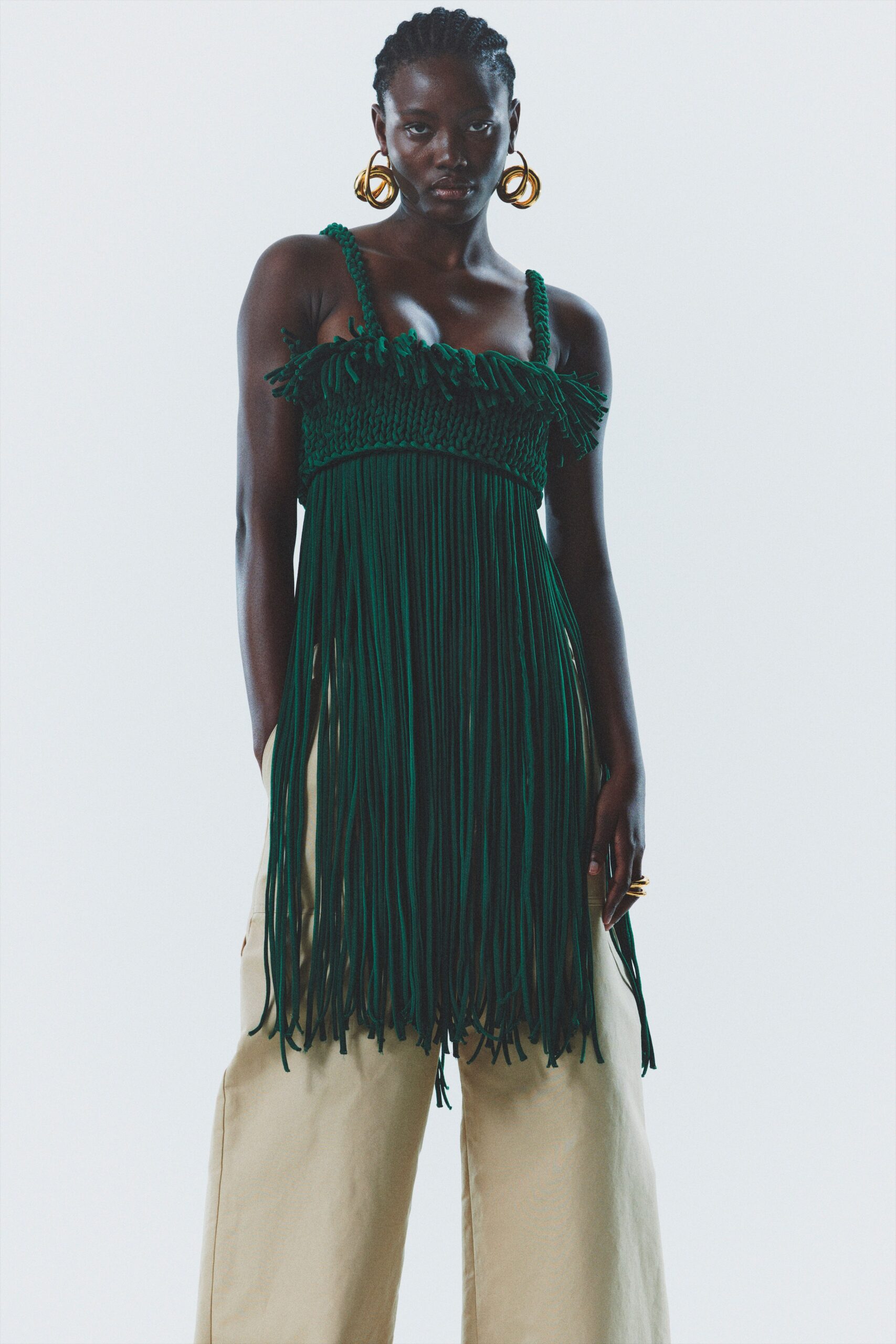 green fringed top with beige pants