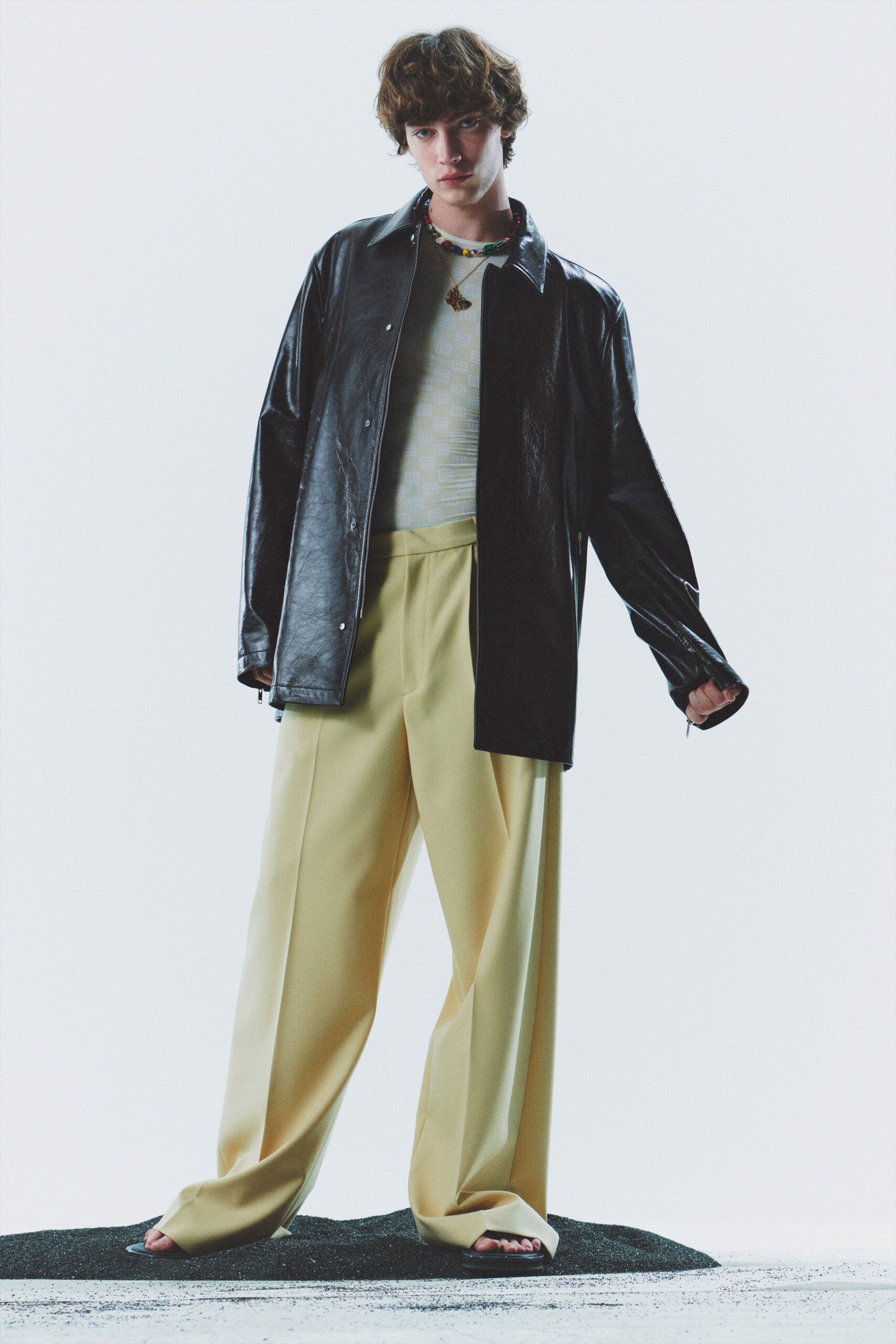 black leather jacket with white top and yellow pants