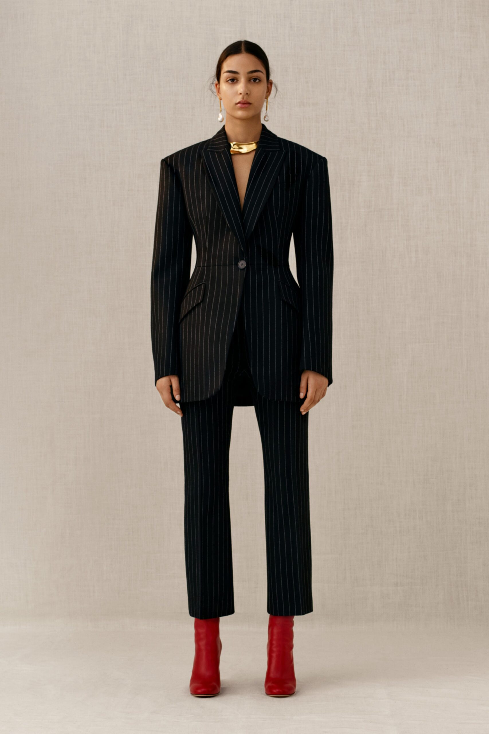 tailored black striped suit with red shoes