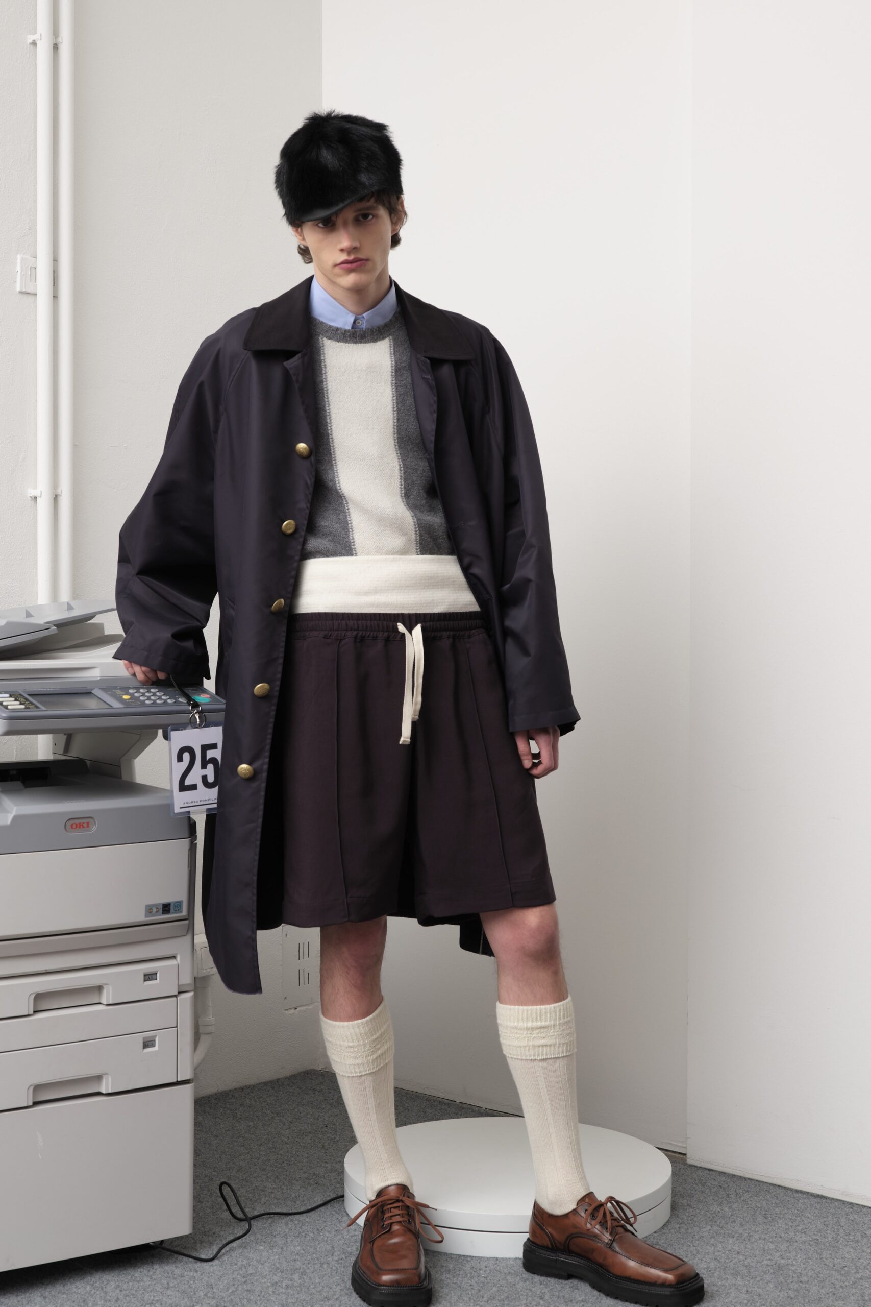black coat gray sweater brown shorts