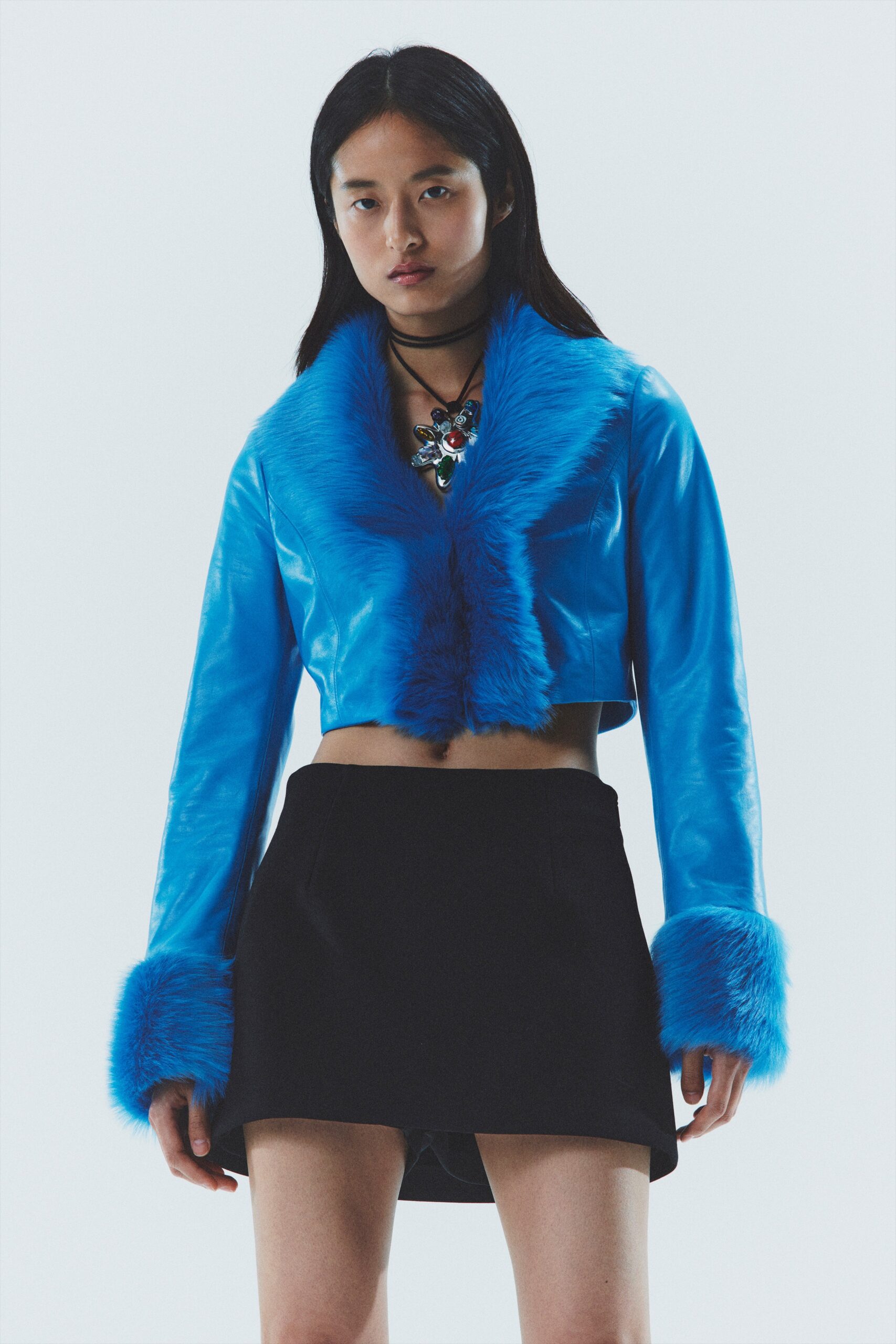 blue leather cropped jacket and black skirt
