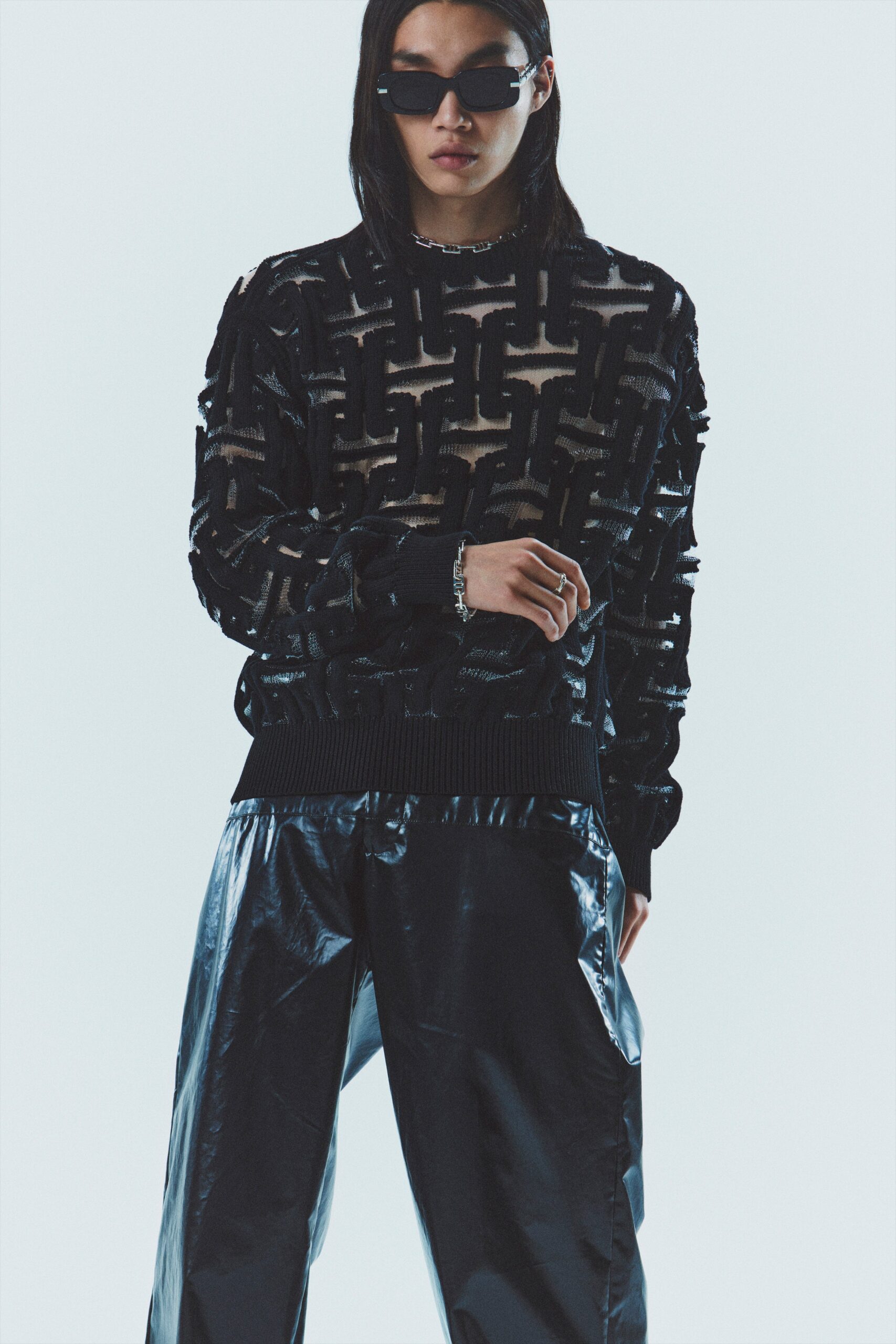 black textured sweater and vinyl pants