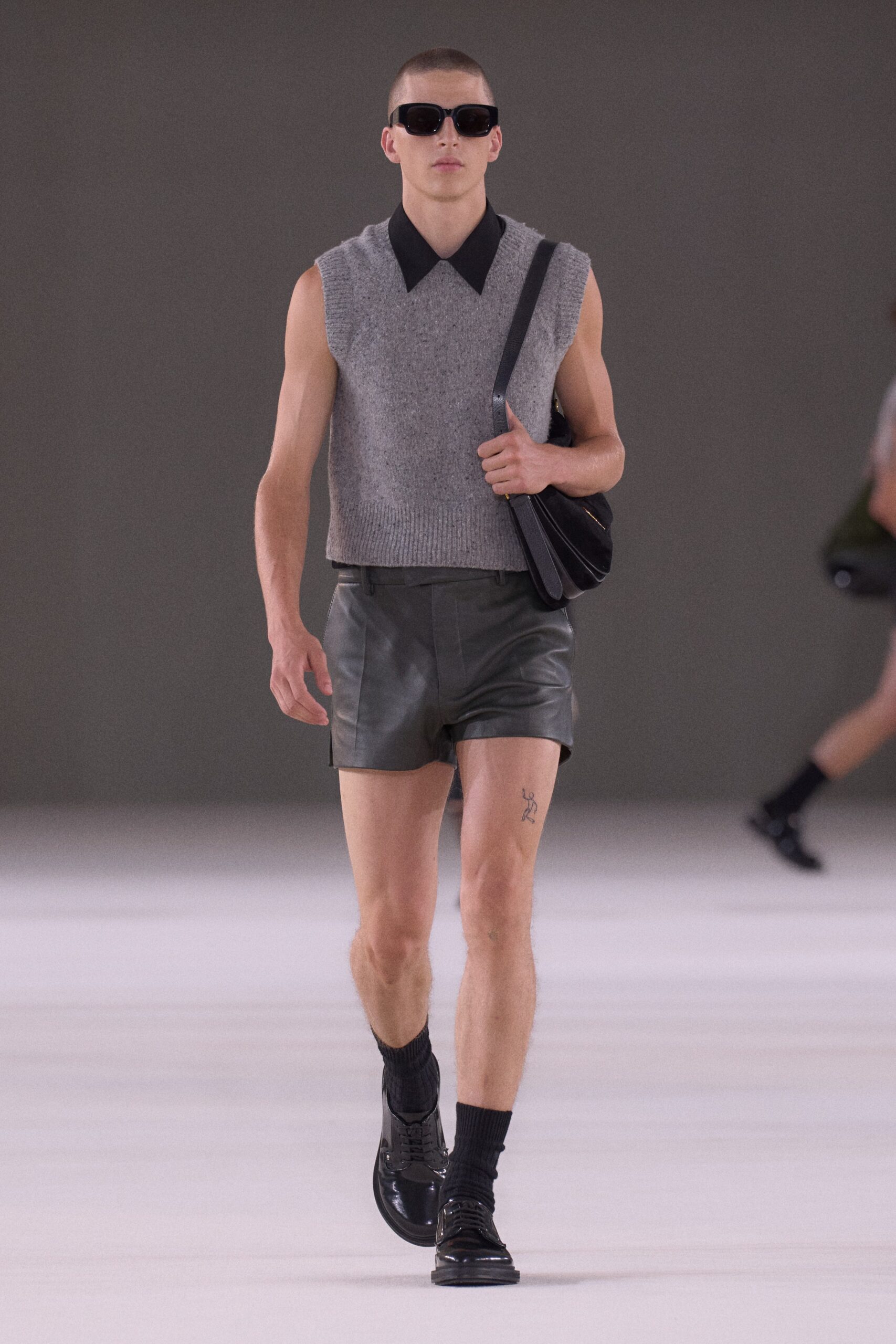 gray sleeveless sweater and black shorts