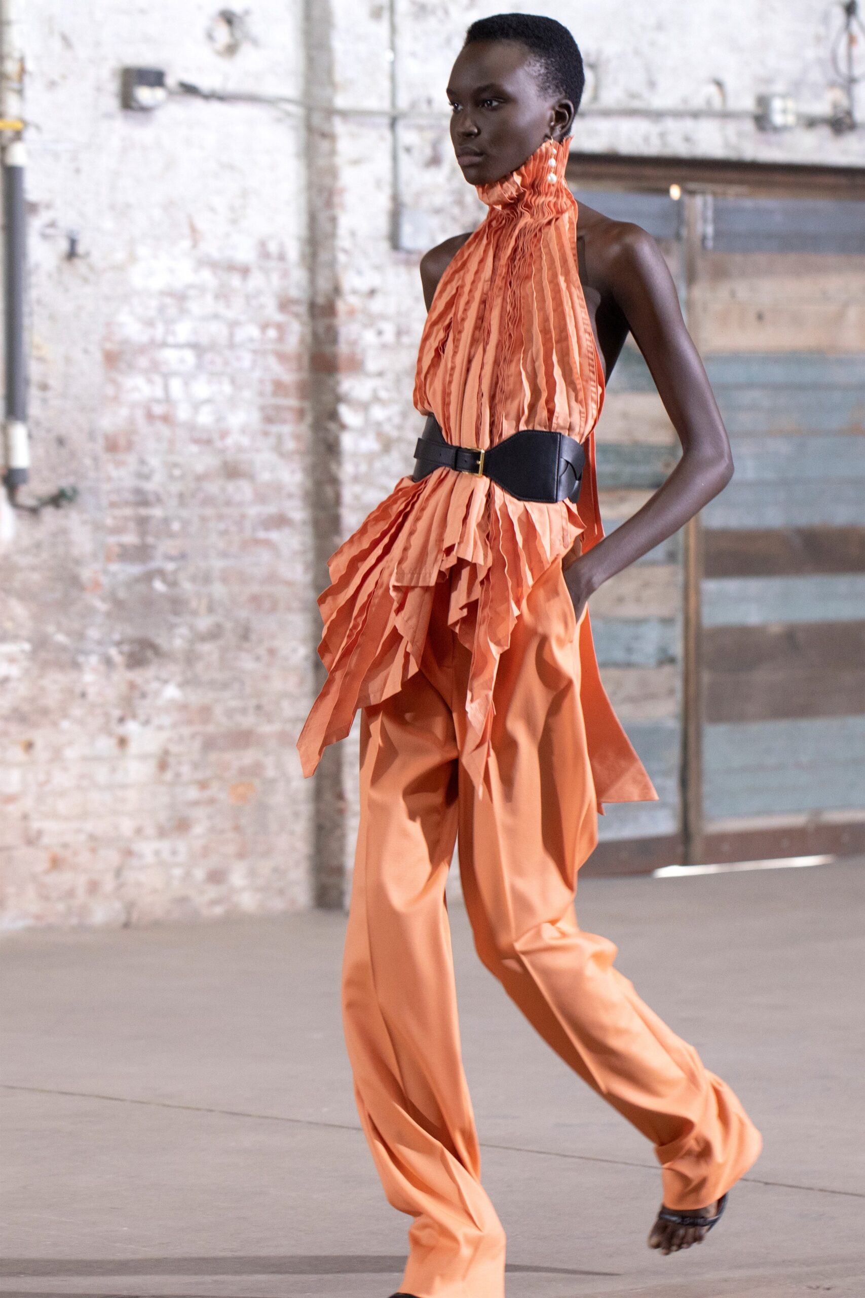 orange ruffled top with black belt