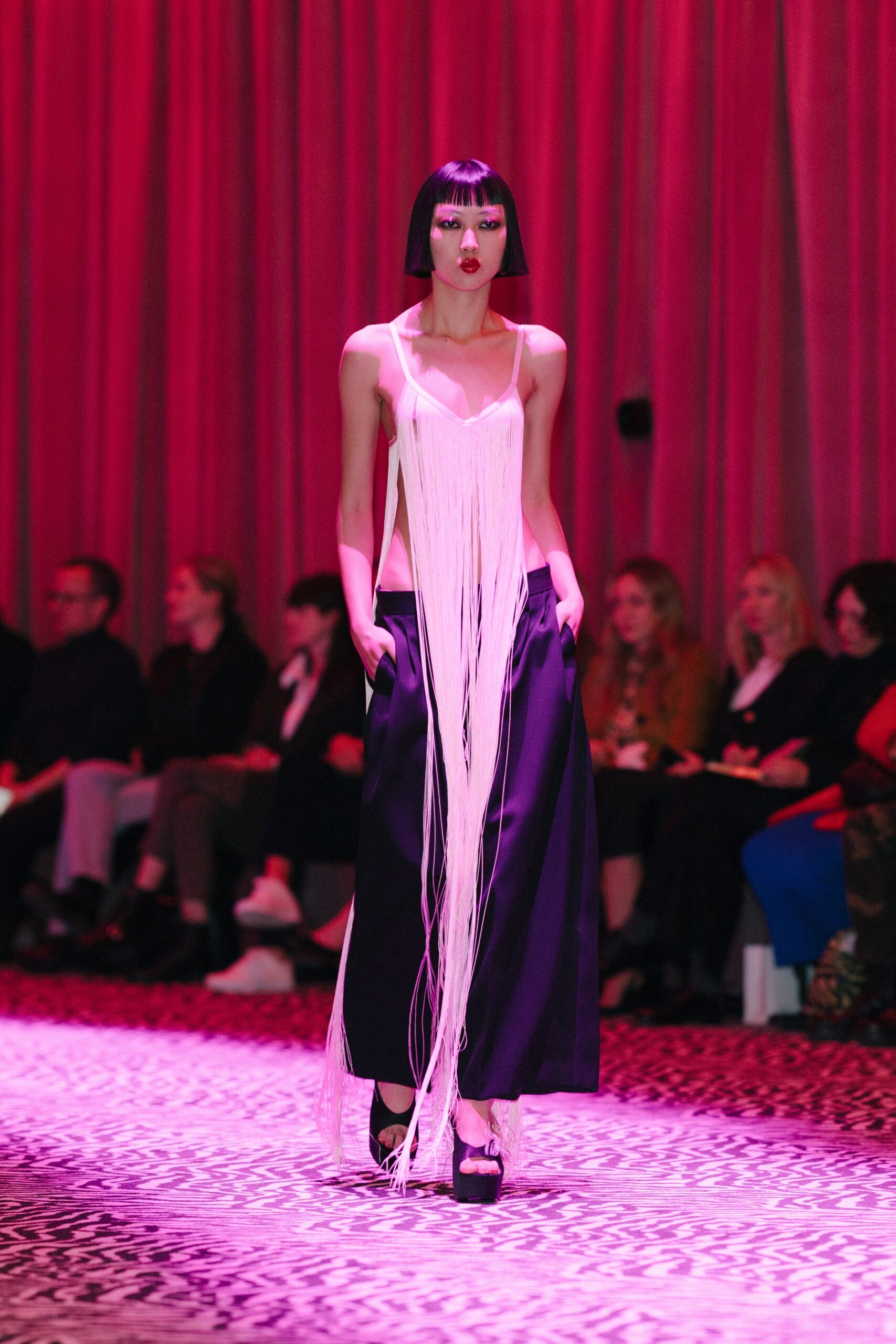 white fringed top and black wide-leg pants