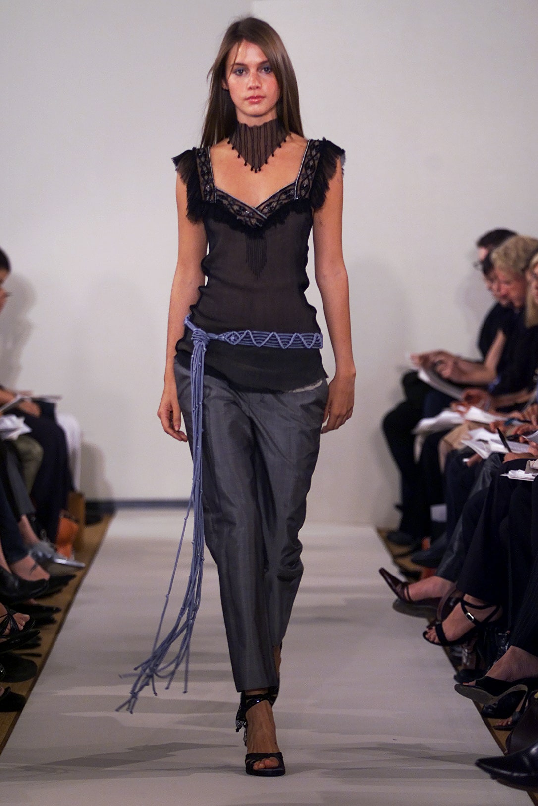black silk sleeveless top and gray pants