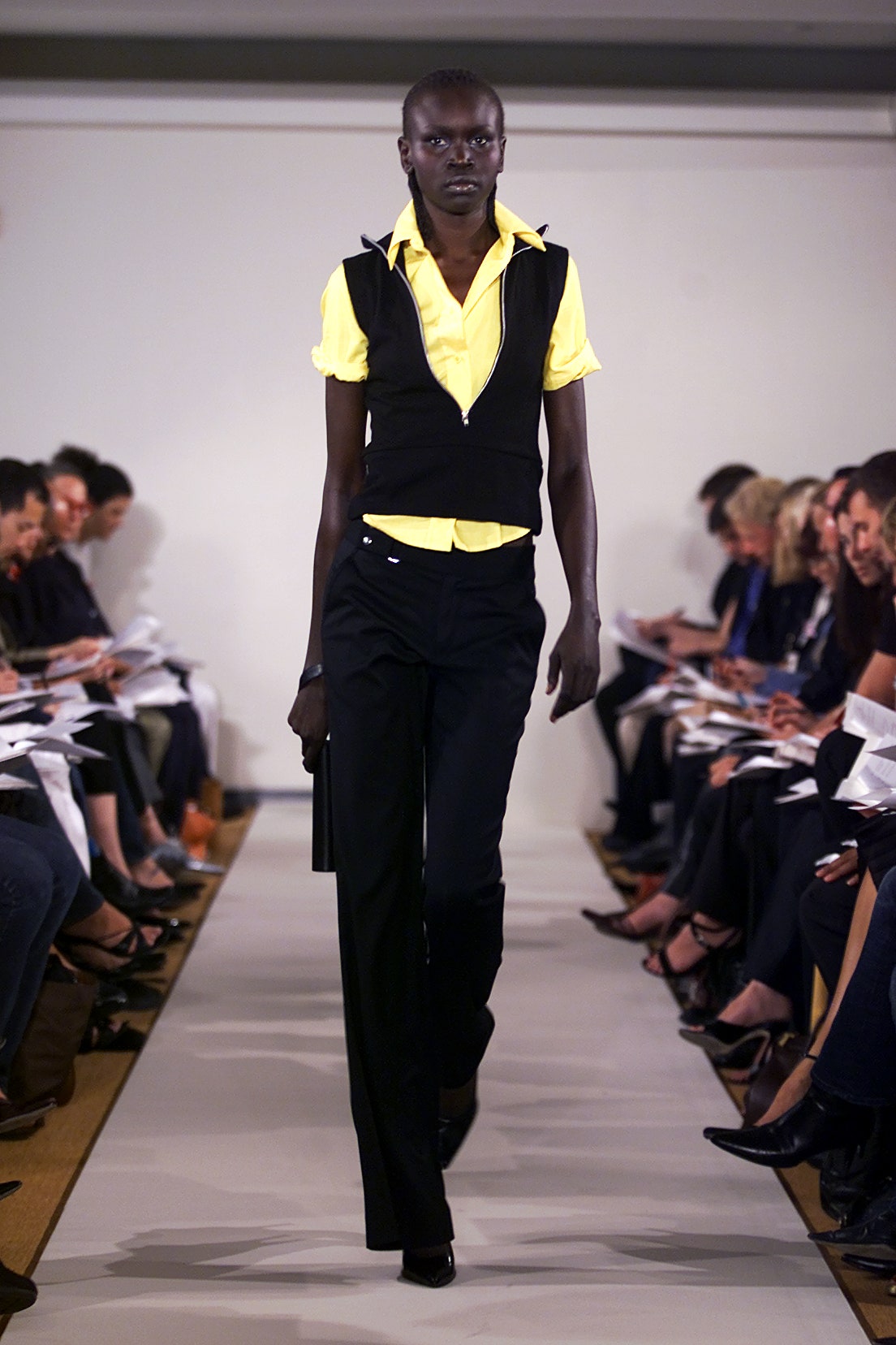 yellow top black vest and pants