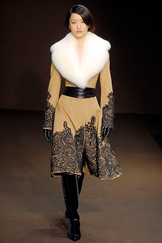 beige embroidered coat with black gloves