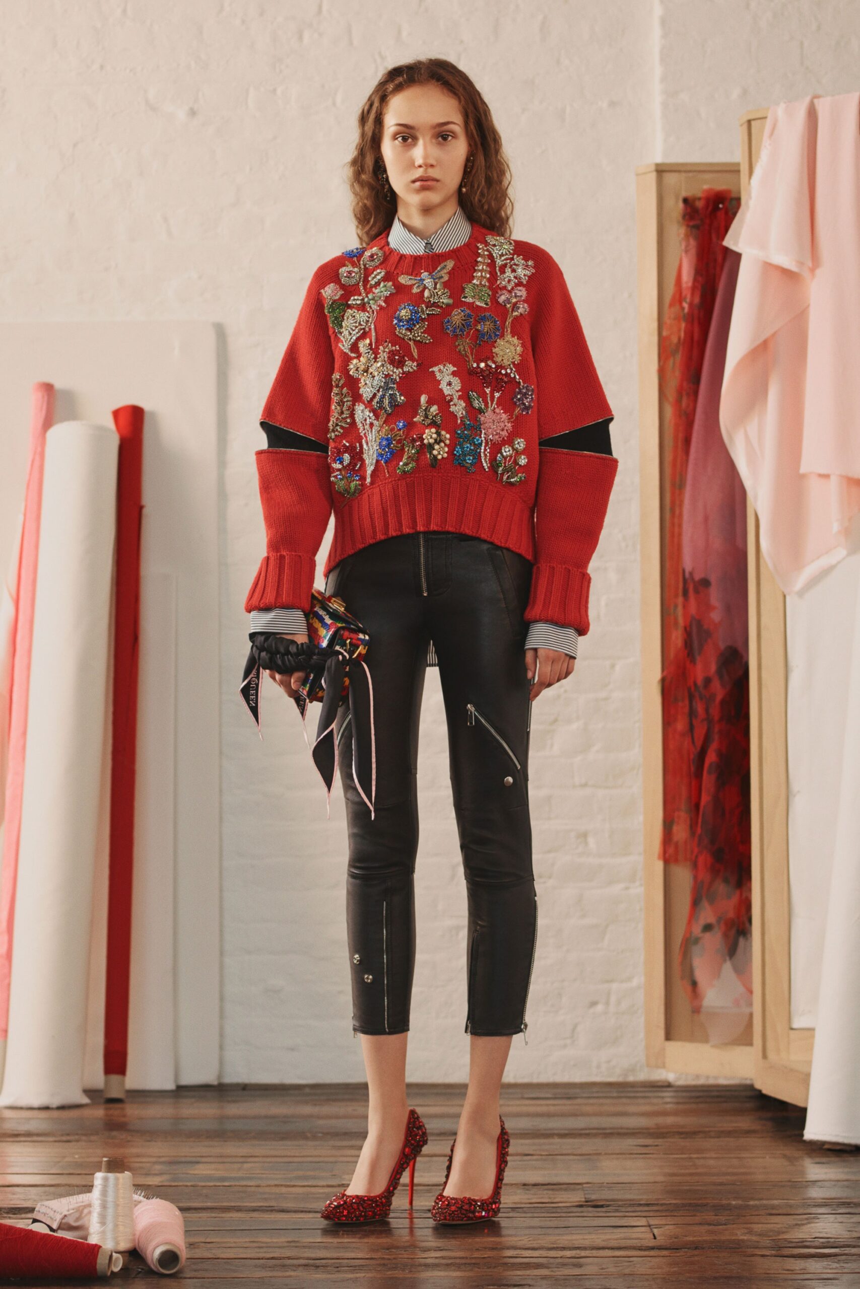 red embroidered sweater with black leather pants