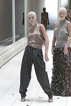 beige silk sleeveless top and black pleated pants