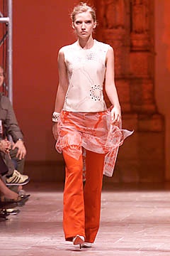 white silk fitted top and orange tailored pants