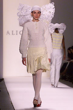 white fitted sweater and yellow pleated skirt