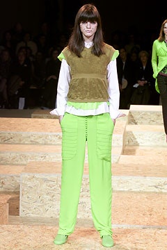 brown velvet sleeveless top with white shirt and green pants