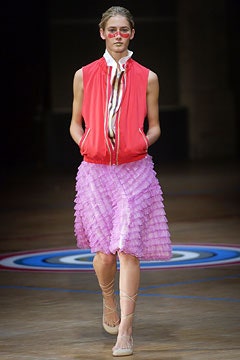 red sleeveless jacket and pink pleated skirt