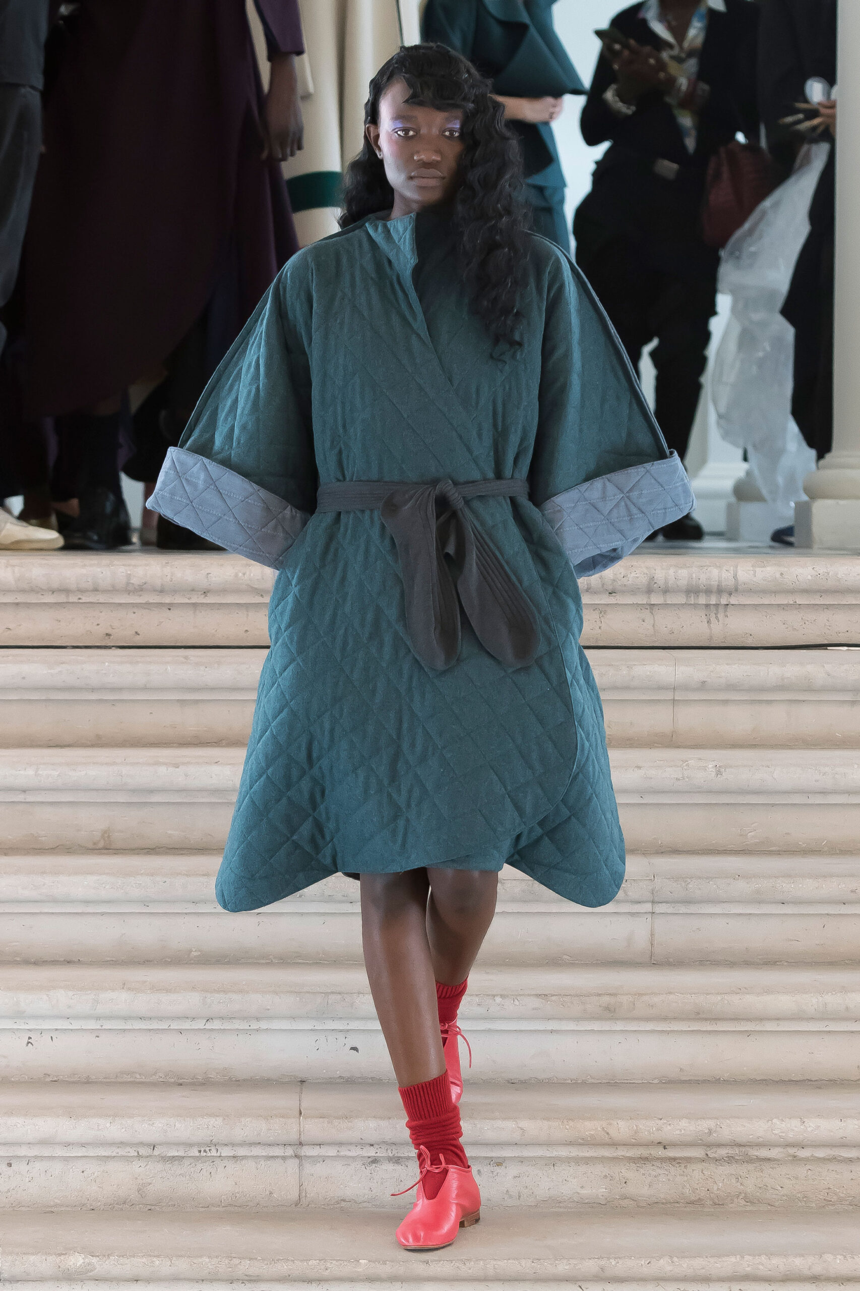 teal quilted coat with red shoes