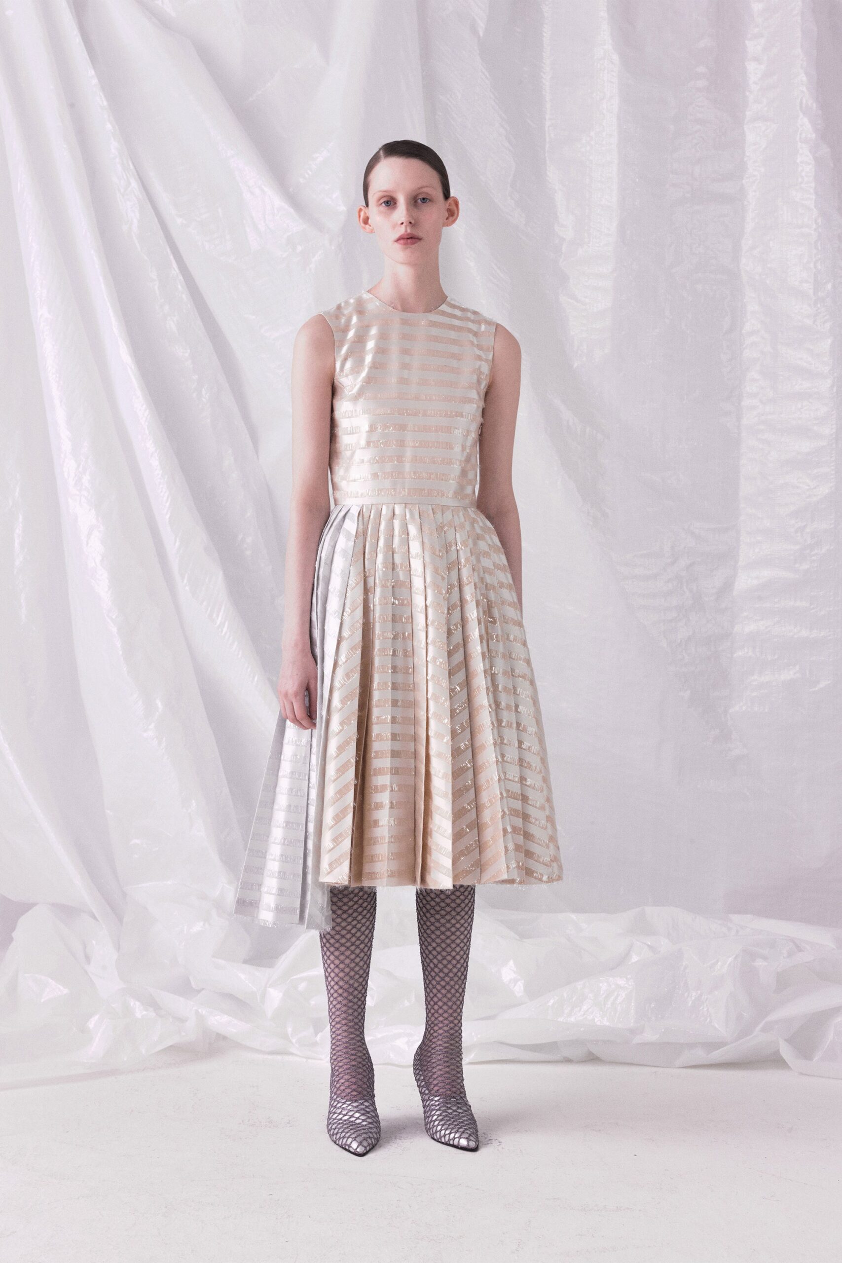 beige pleated midi dress with silver shoes