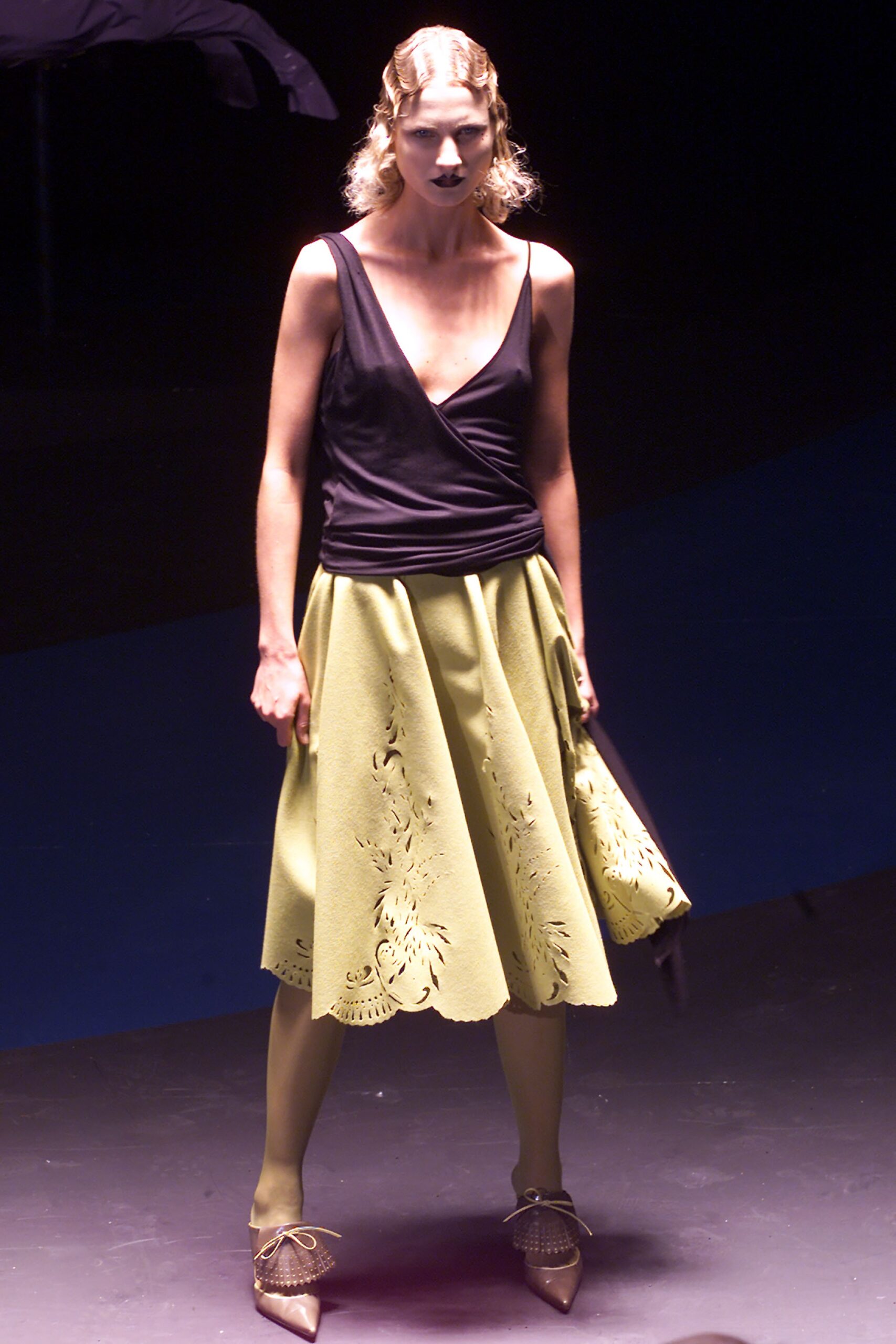 black fitted top with green pleated skirt