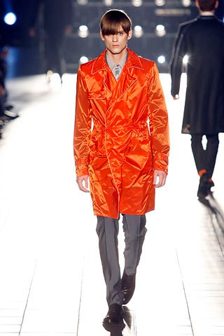 orange satin trench coat and gray tailored pants