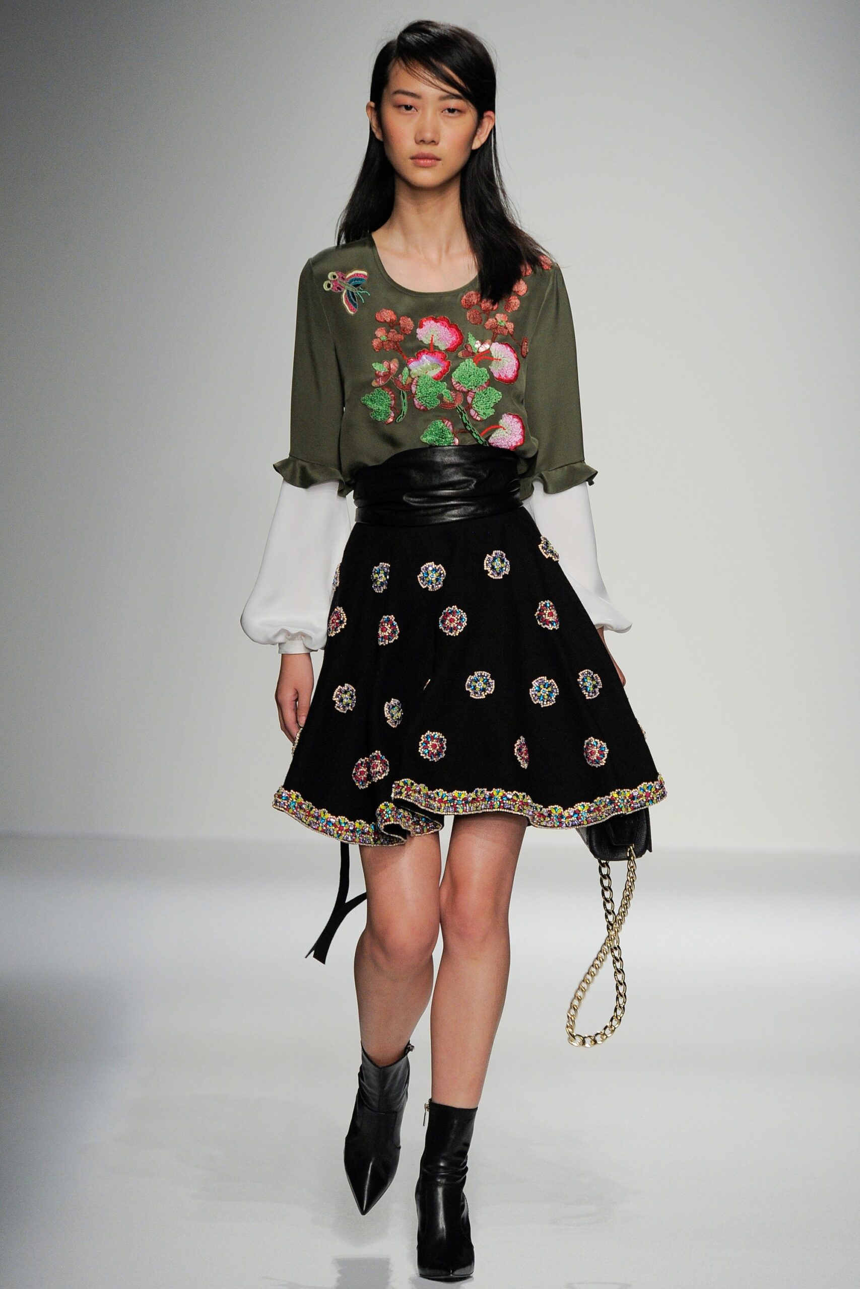 embroidered green blouse and black skirt