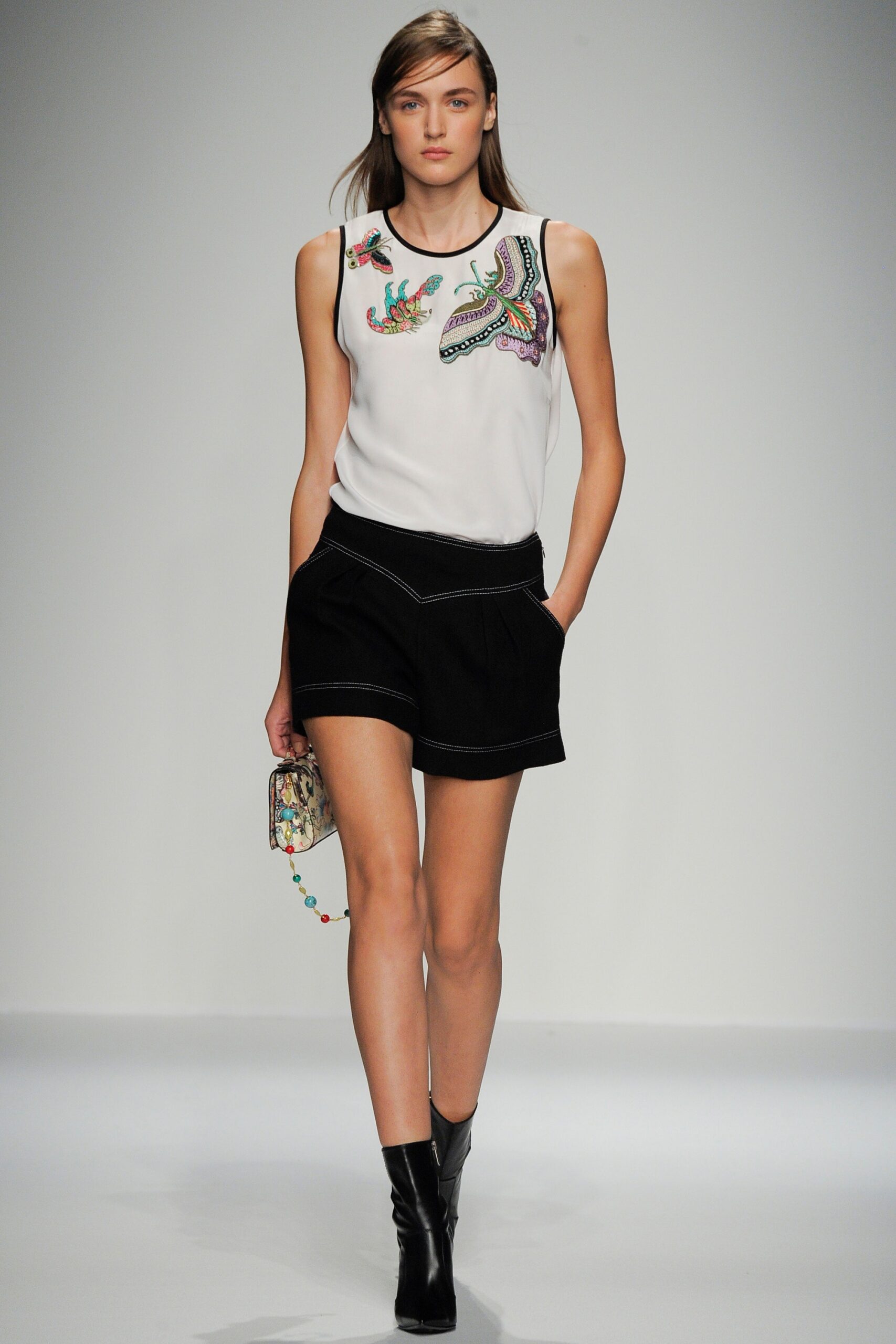 white embroidered sleeveless top with black shorts
