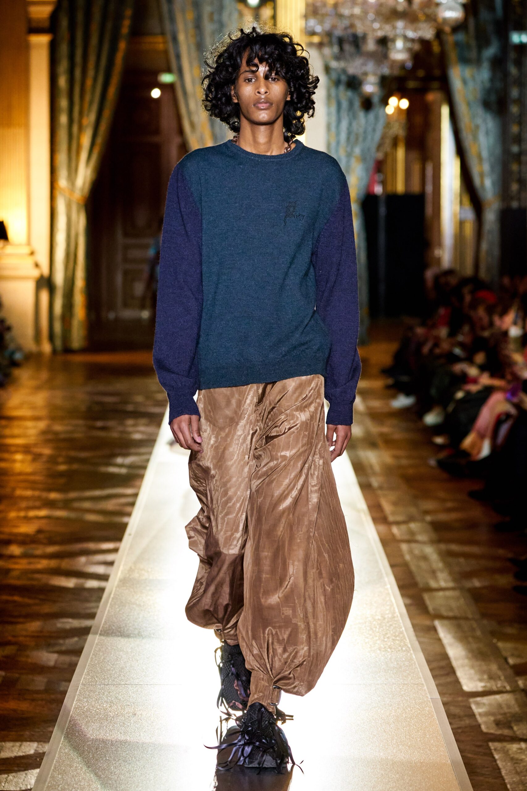 blue relaxed sweater and brown pleated pants