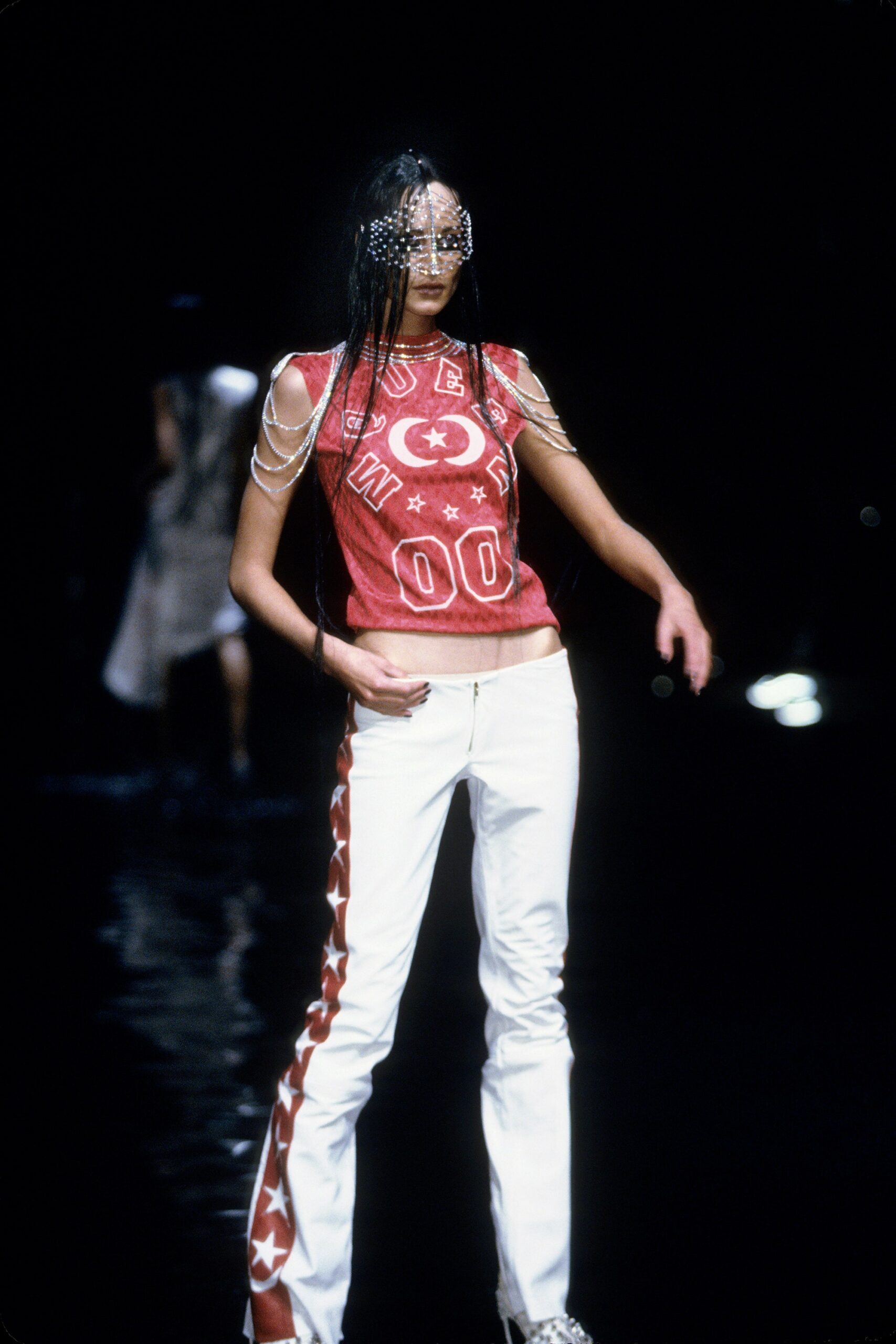 red printed sleeveless top with white pants