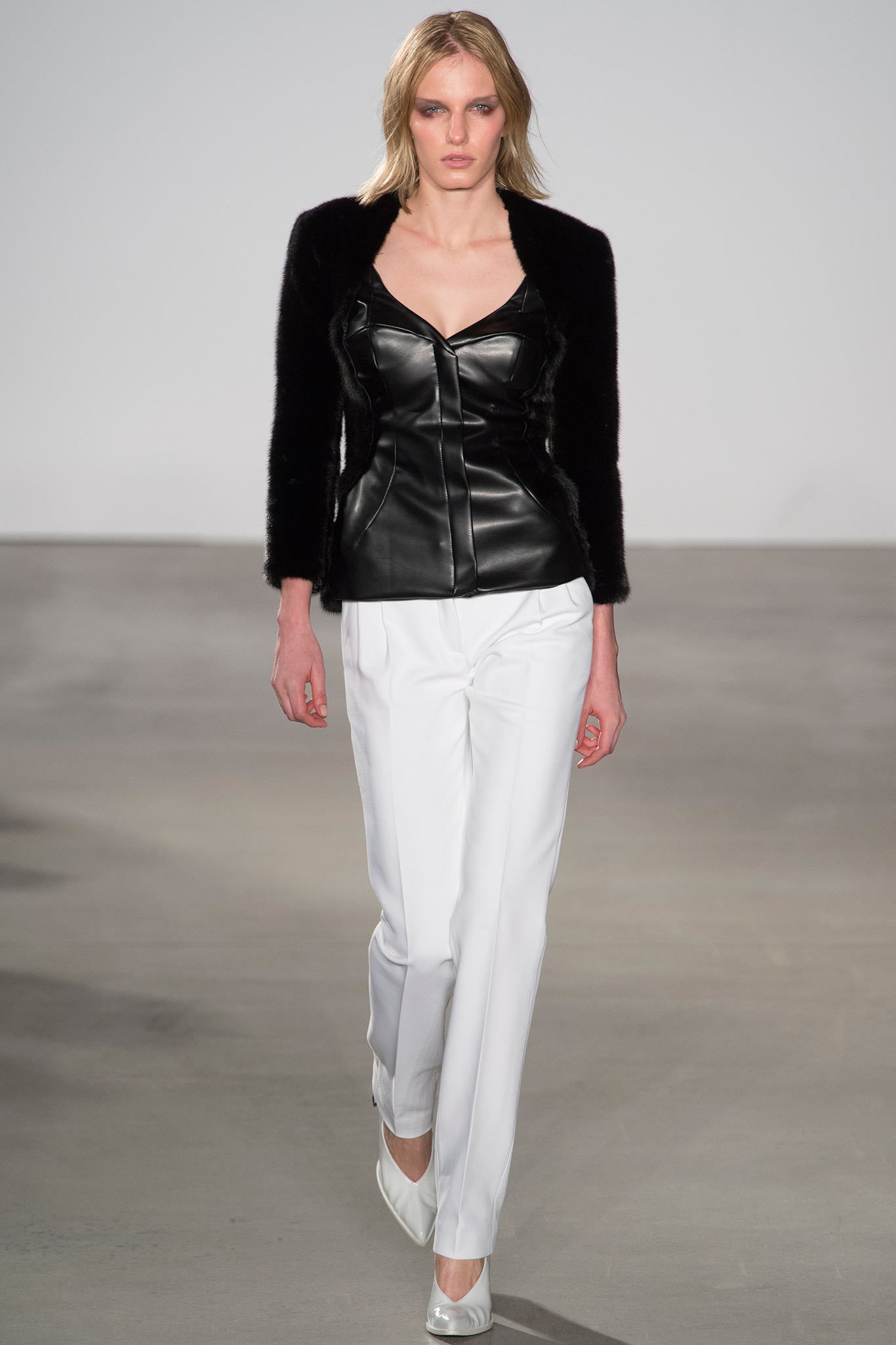 black leather sleeveless top and white tailored pants